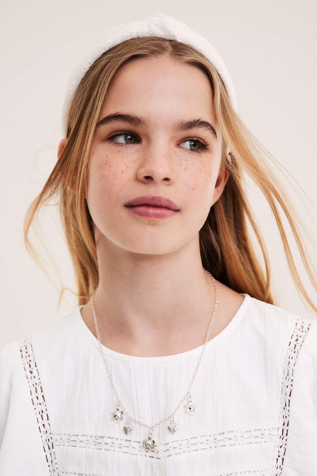 Biała bawełniana bluzka dla dziecka z koronkami i marszczeniem w talii, przód.