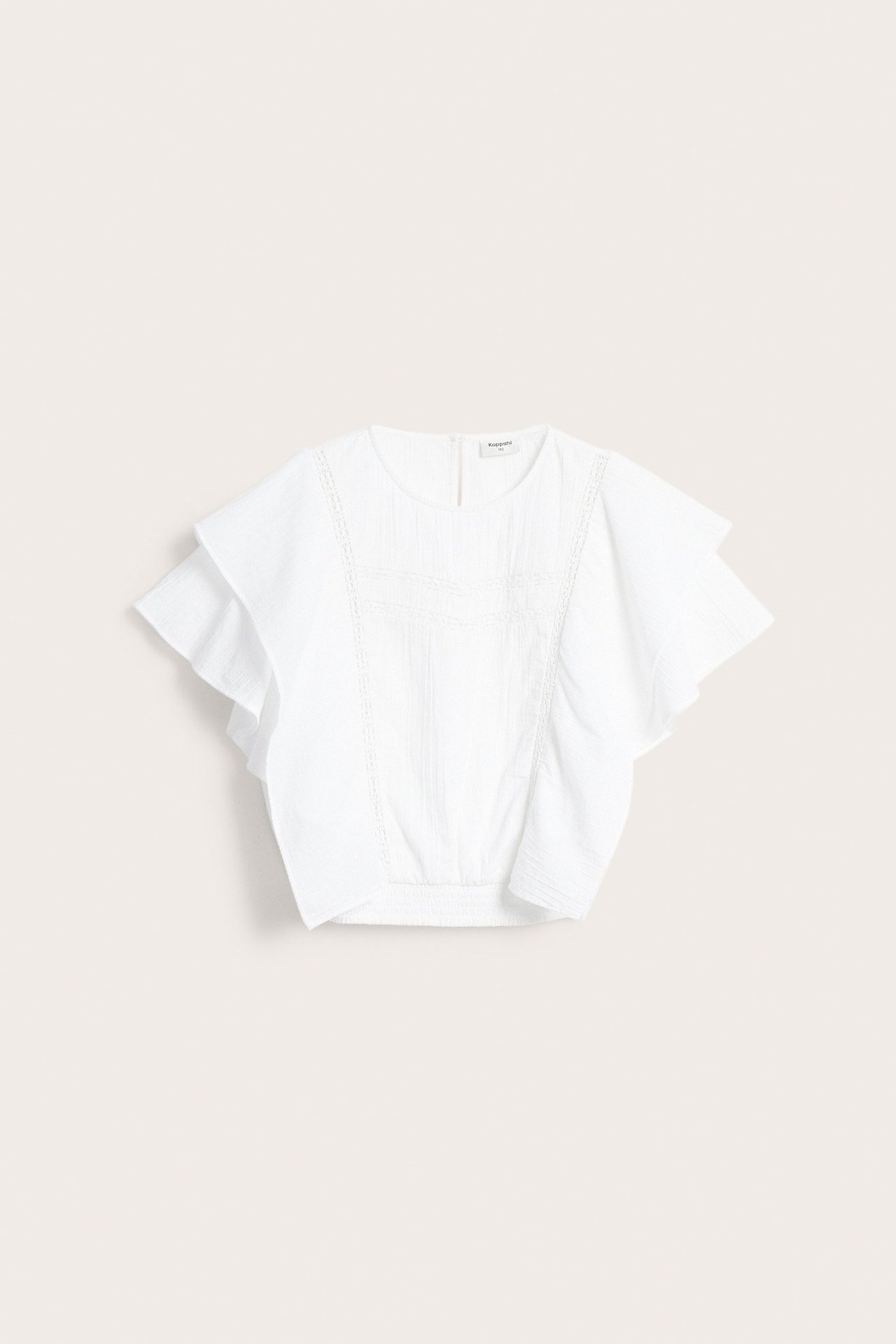 Frontvy av vit bomullsblus med fladdermusärmar, spetsdetaljer och smock i midjan.