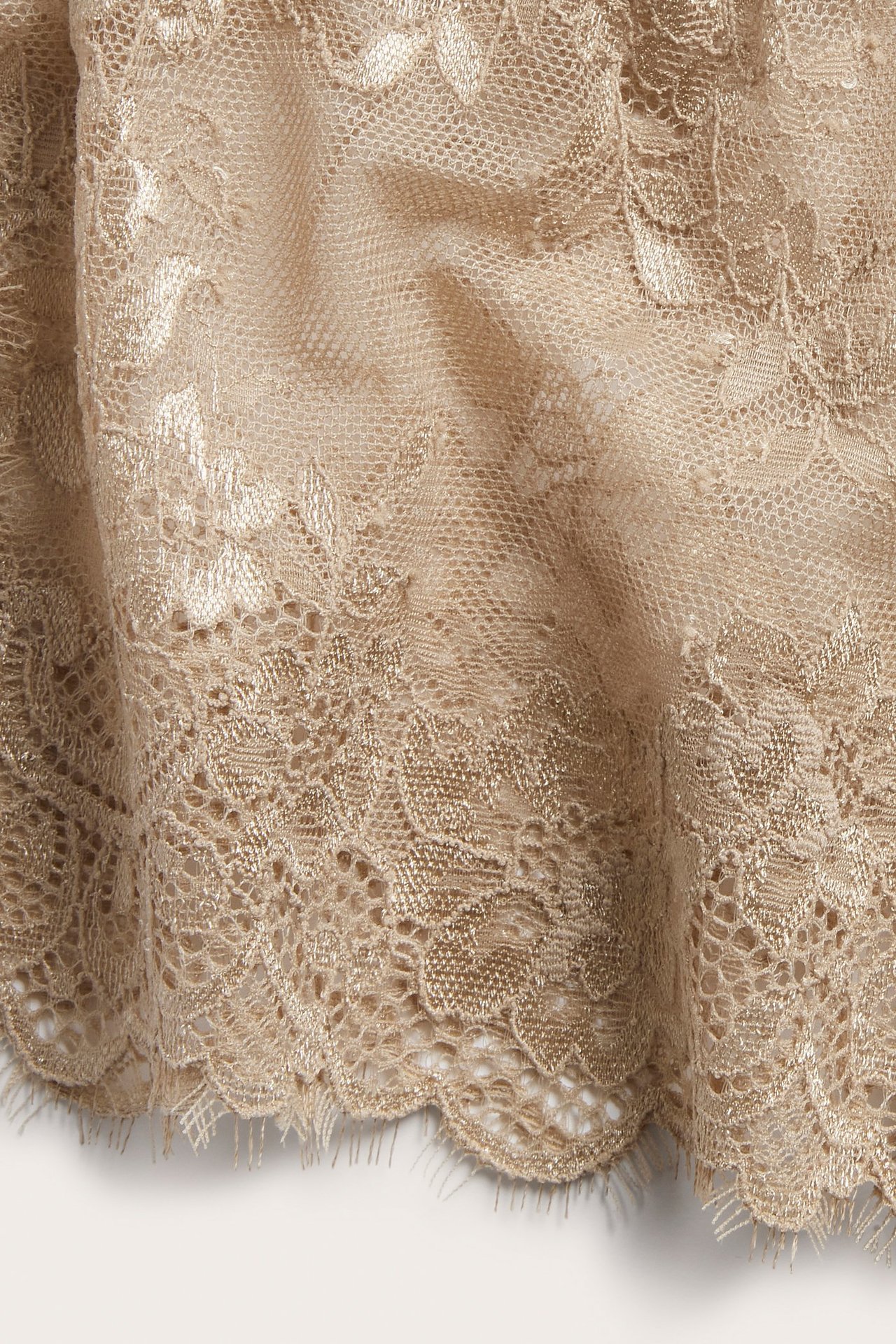 Zbliżenie na brązowe koronkowe figi, z falistym brzegiem i delikatną frędzlą.