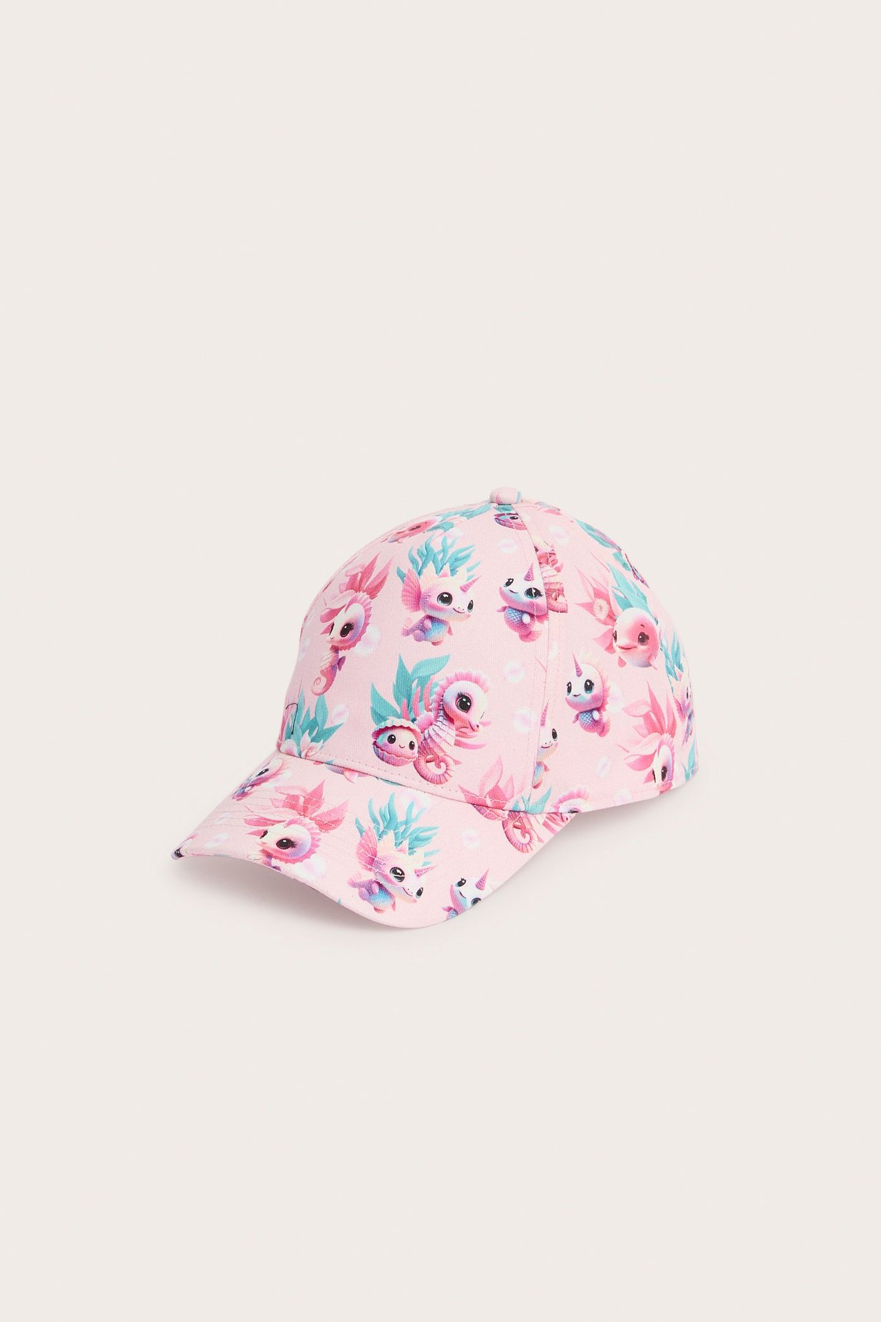 Widok z przodu pod kątem: różowa czapka dziecięca w kolorowy wzór koników morskich i życia morskiego.