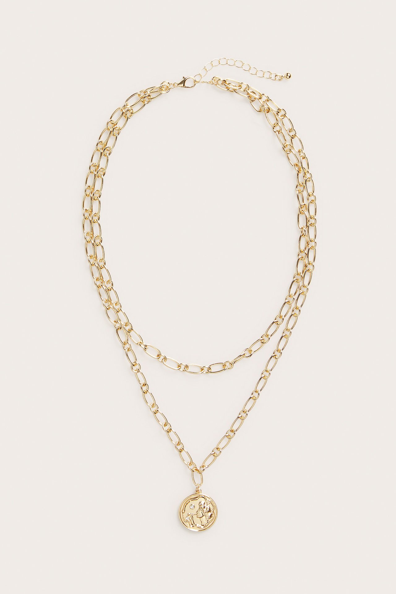 Widok z przodu: złoty, dwuwarstwowy naszyjnik z łańcuszków z okrągłą zawieszką-medalionem.