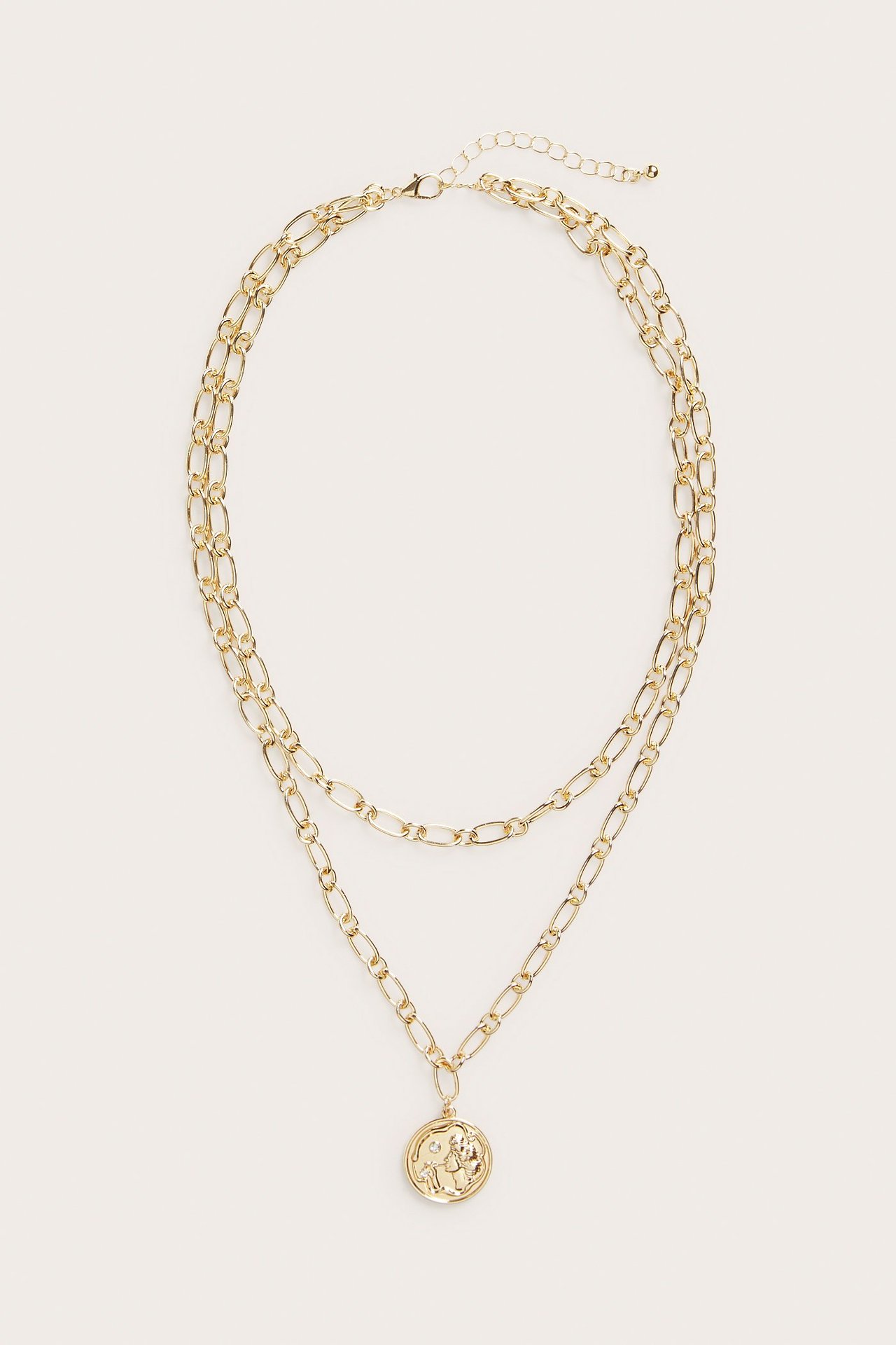 Edestä näkymä kultaisesta kaksikerroksisesta ketjukaulakorusta pyöreällä medaljonkiriipuksella.