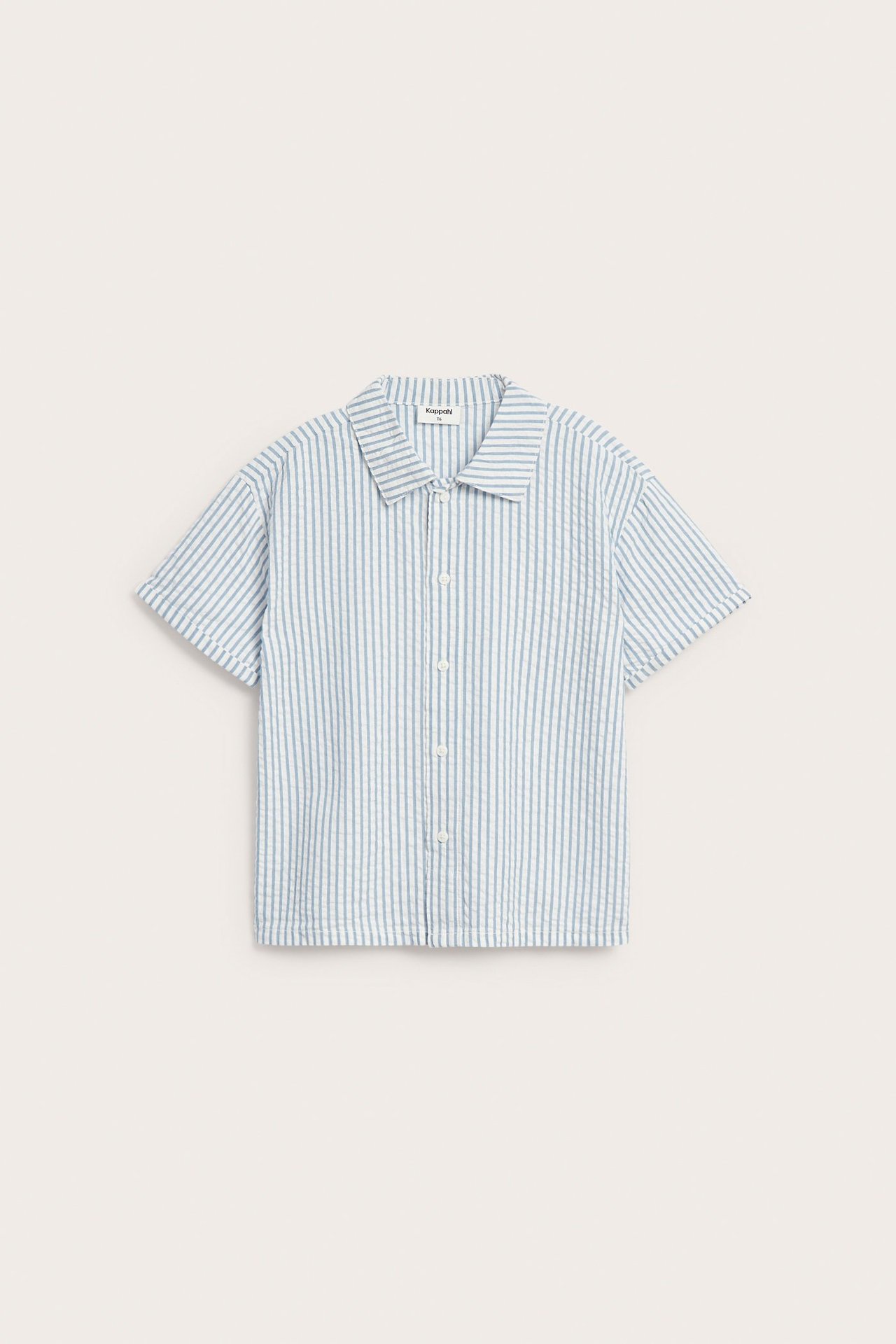 Widok z przodu. Krótka koszula w niebiesko-białe paski, bawełniana seersucker, zapinana na guziki.