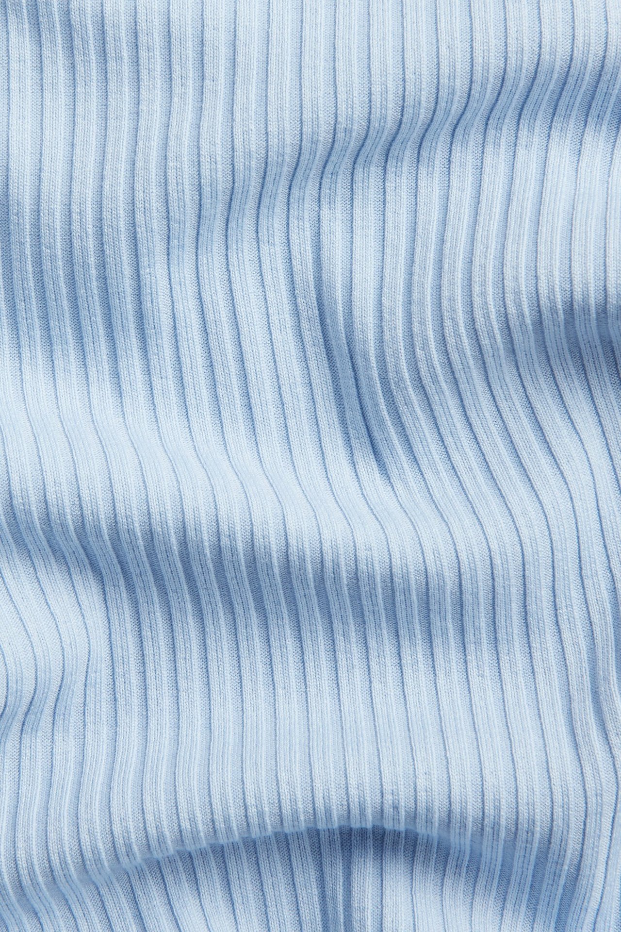 Lähikuva vaaleansinisestä ribatusta topista pystysuoralla kuvioinnilla.