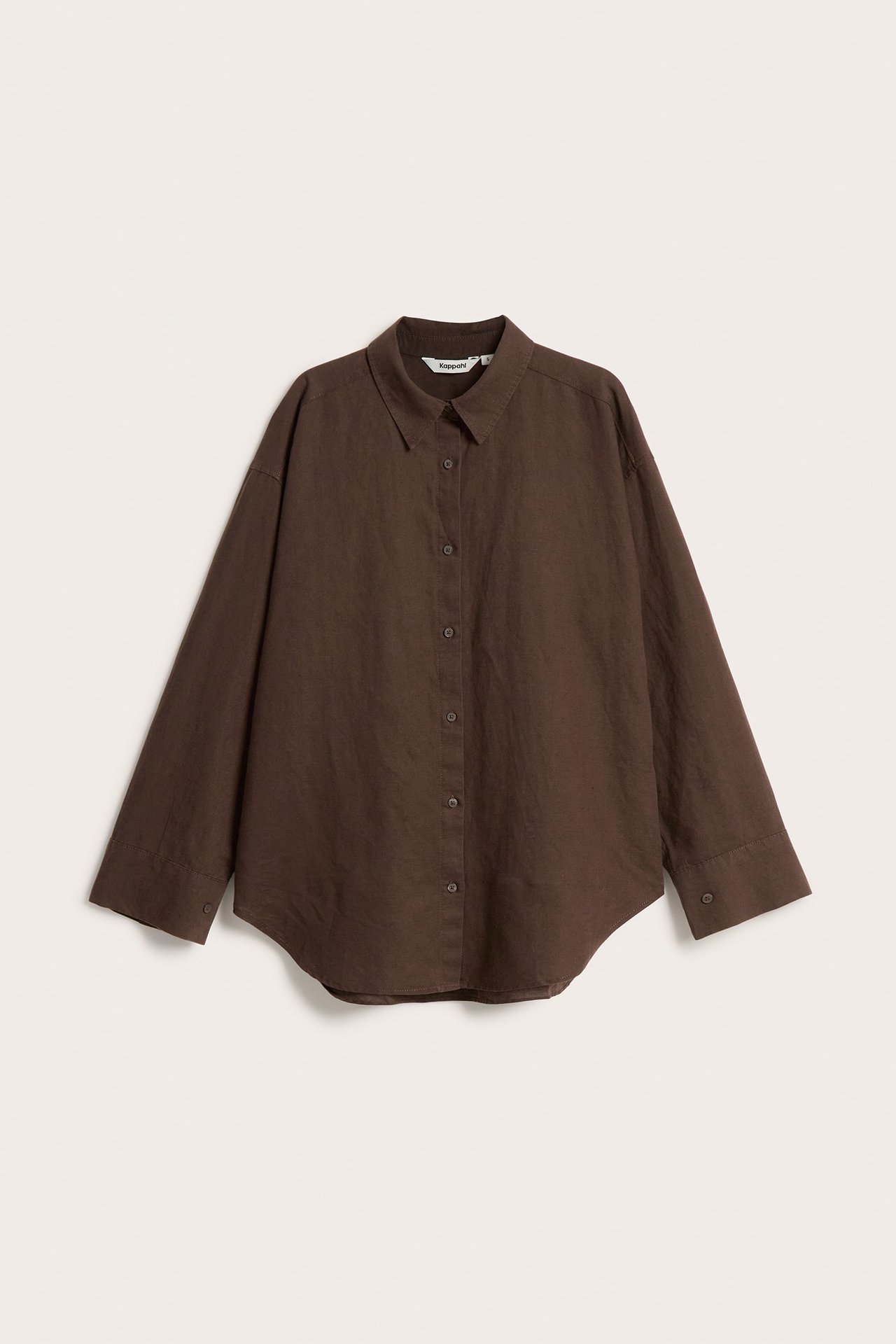 Edestä kuvattu yksivärinen tummanruskea oversized pellavasekoitepaita napituksella.