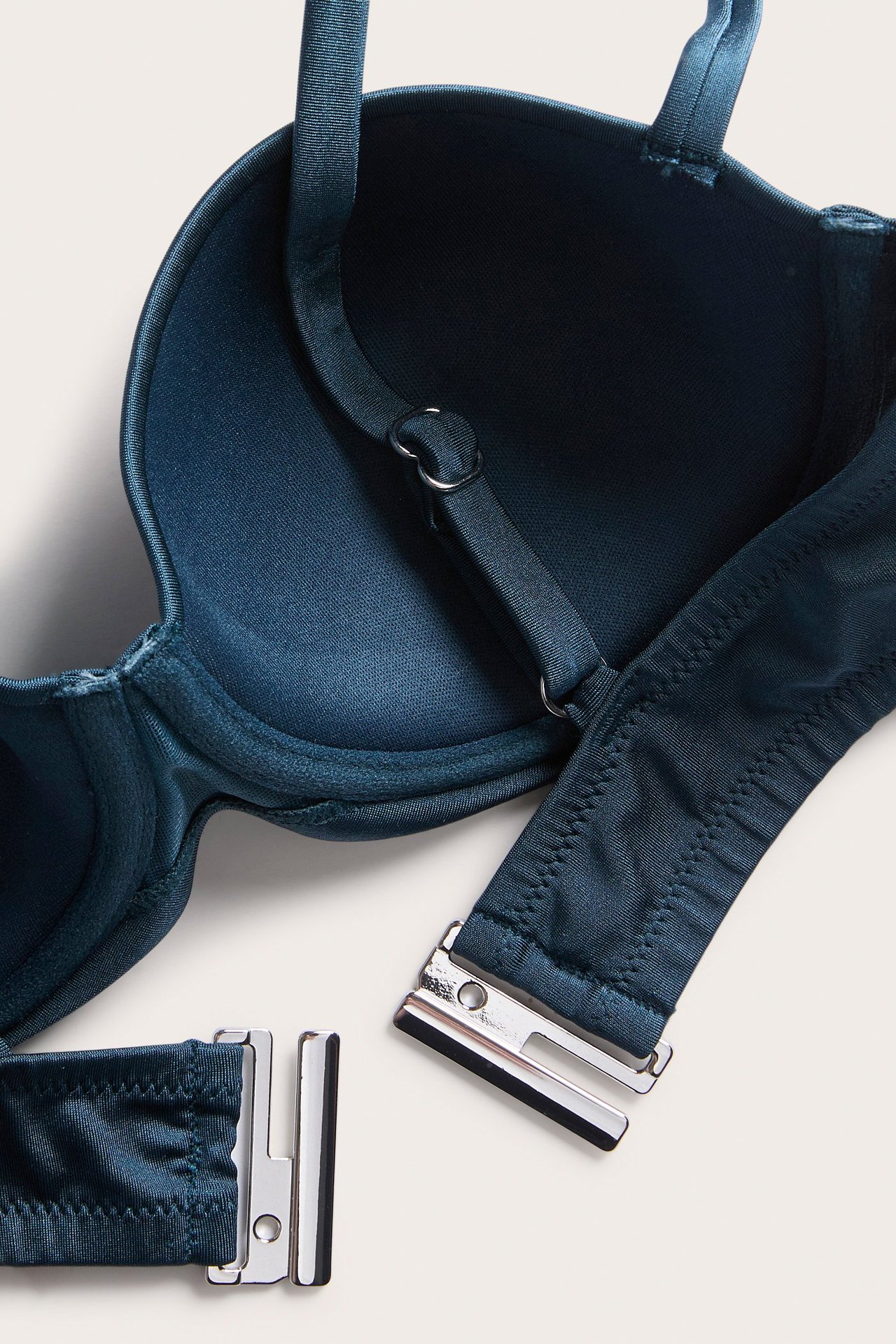 Lähikuva tummansinisestä yksivärisestä balconette-bikini-rintaliivistä, jossa on kiinteä pehmuste ja hopeanvärinen lukko.