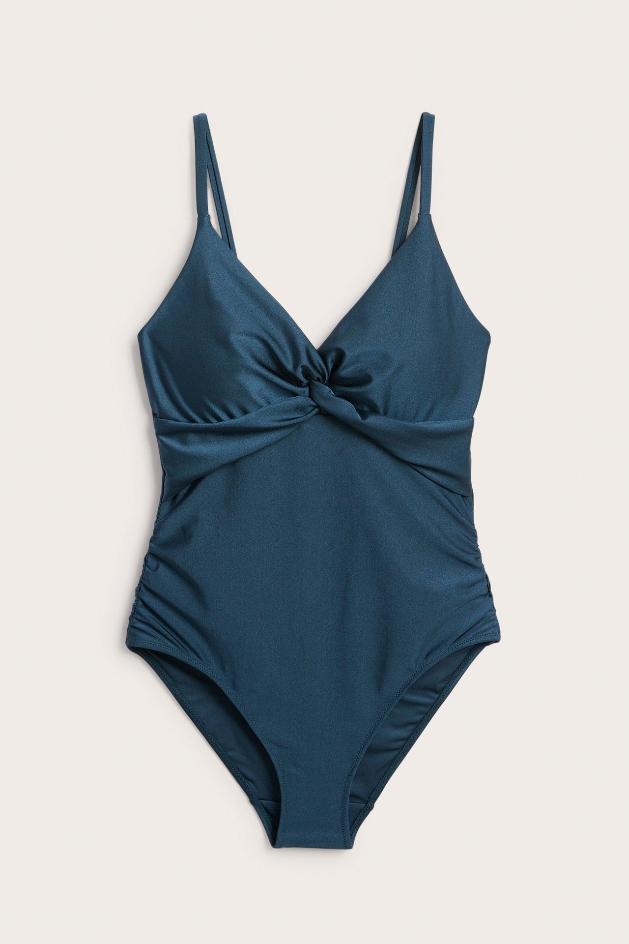 Frontbilde: Mørkeblå badedrakt med vridd front og rynkede sider, lett formende.