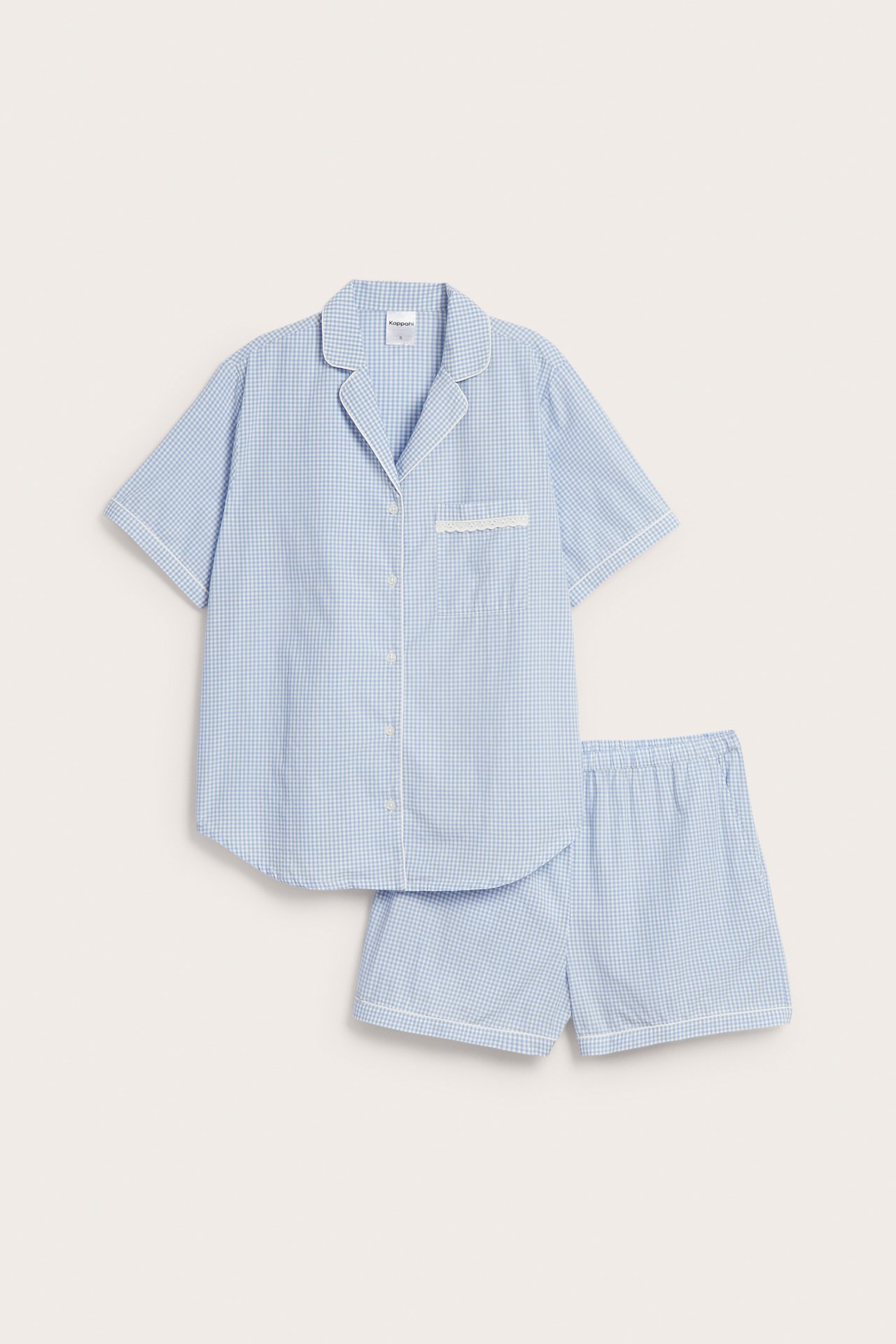 Forfra: blåhvitt rutete pyjamassett i bomull, hvit passpoal, blondedetaljert skjortelomme, shorts.