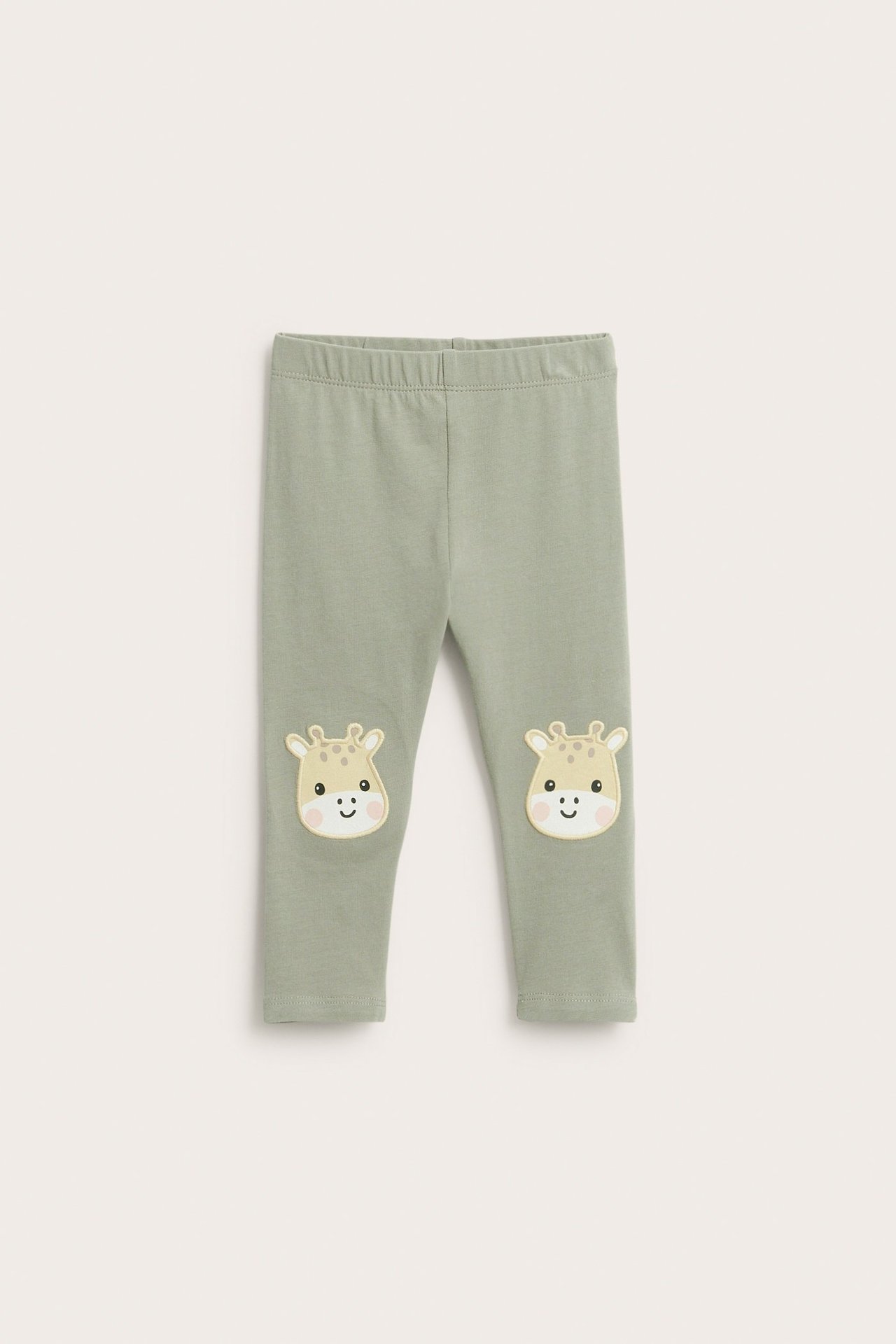 Edestäpäin vauvan tummanvihreät leggingsit pehmeällä vyötäröllä ja kirahviapplikaatioilla polvissa.