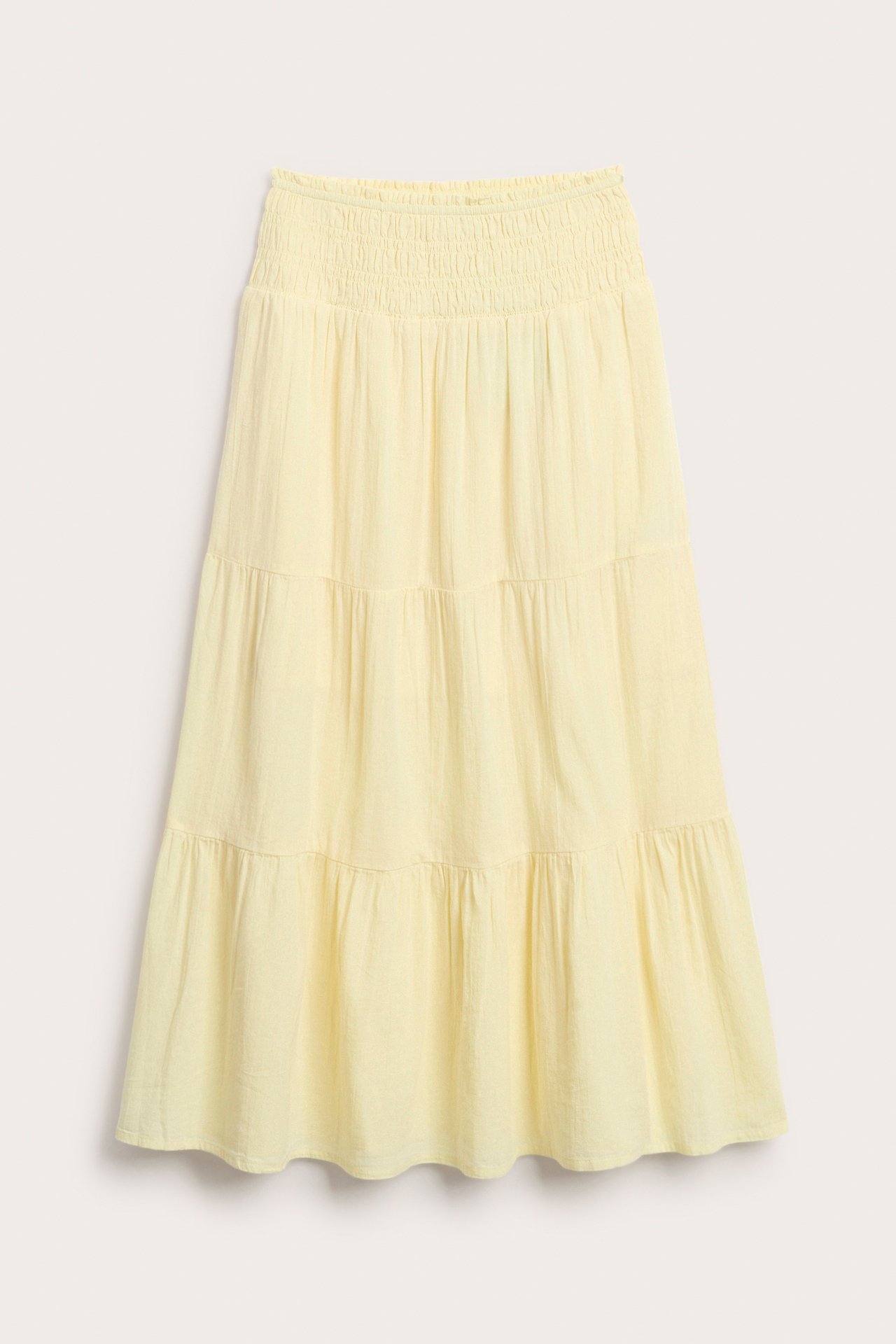 Edestä kuvattu vaaleankeltainen röyhelöinen maksihame kudottua puuvillaa, jossa smock-vyötärö.