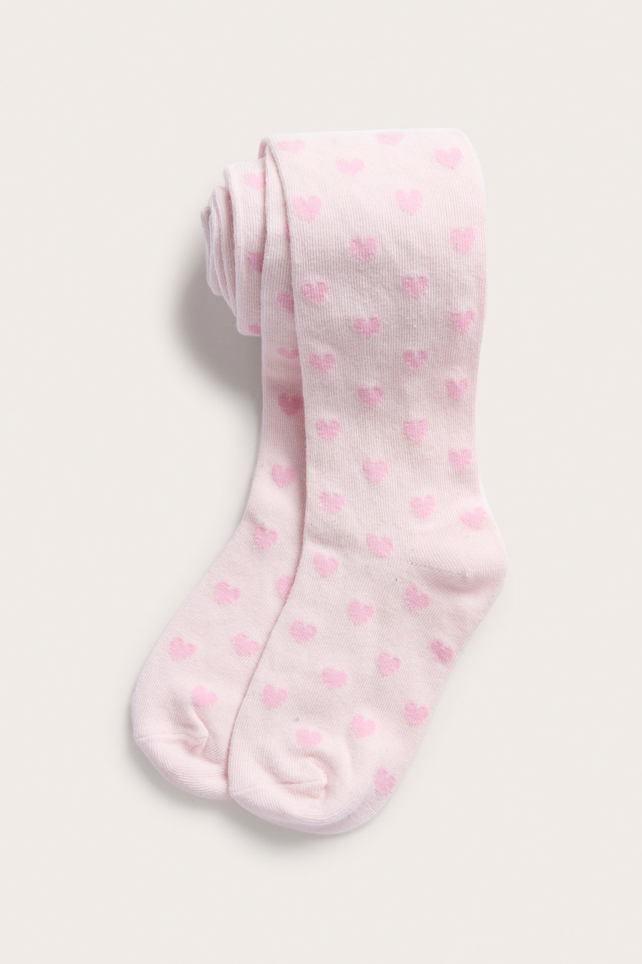 Ylhäältä kuvattuna vaaleanpunaiset lasten jacquard-sukkahousut vaaleanpunaisilla sydämillä, taiteltuna.