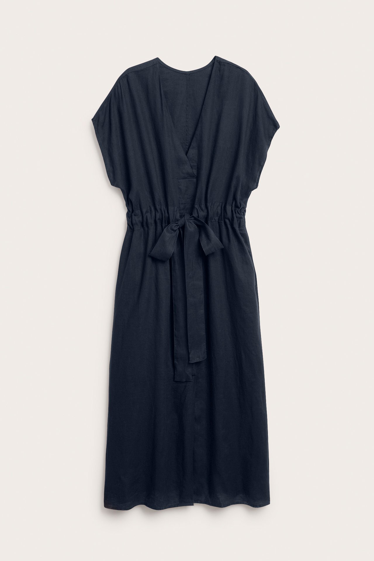 Framsida av en mörkblå lång linneklänning med V-ringning och knytband i midjan.