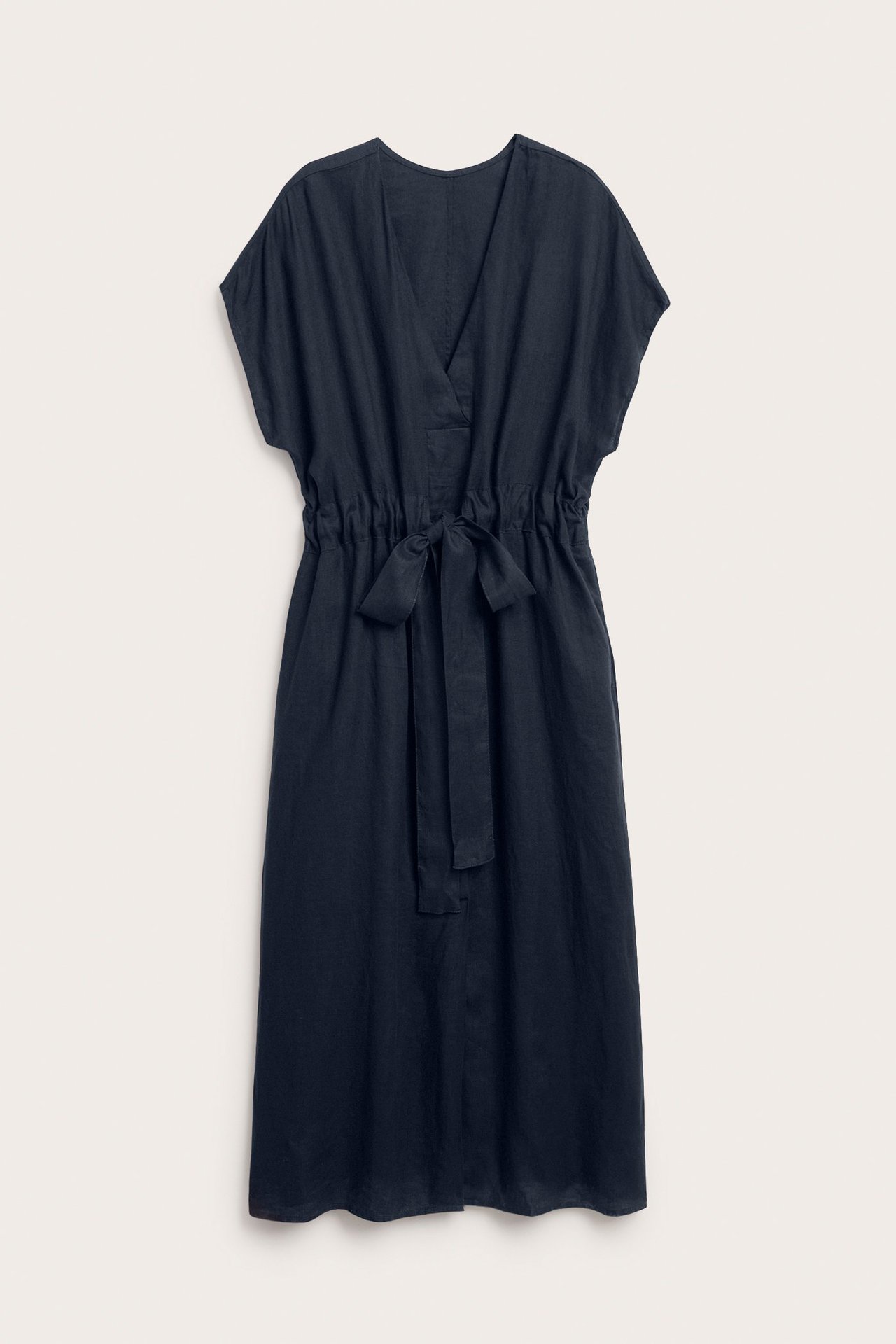 Framsida av en mörkblå lång linneklänning med V-ringning och knytband i midjan.