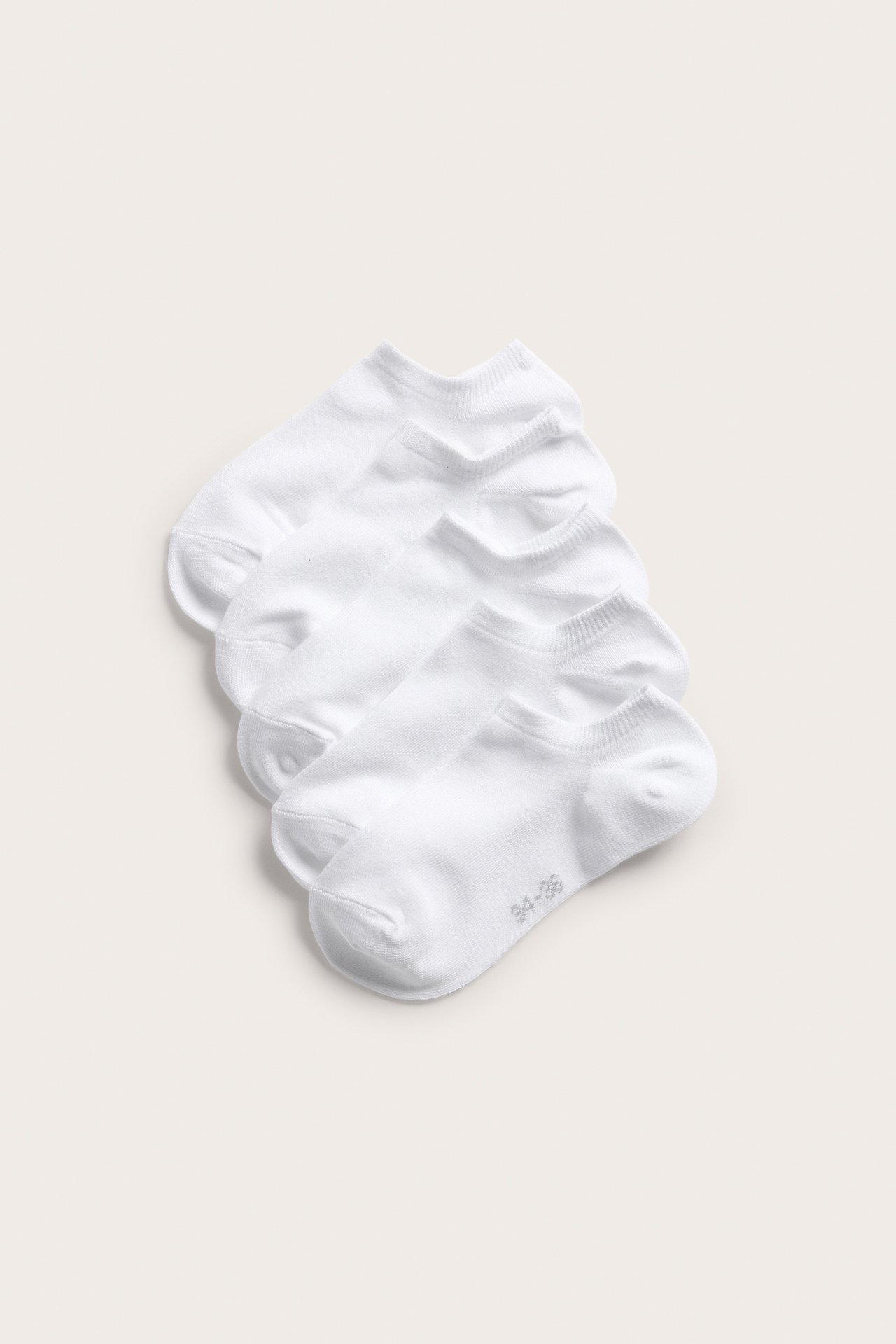 Ylhäältä näkymä viidestä valkoisesta yksivärisestä puuvillasekoite nilkkasukasta, joissakin näkyy koko 34-36.