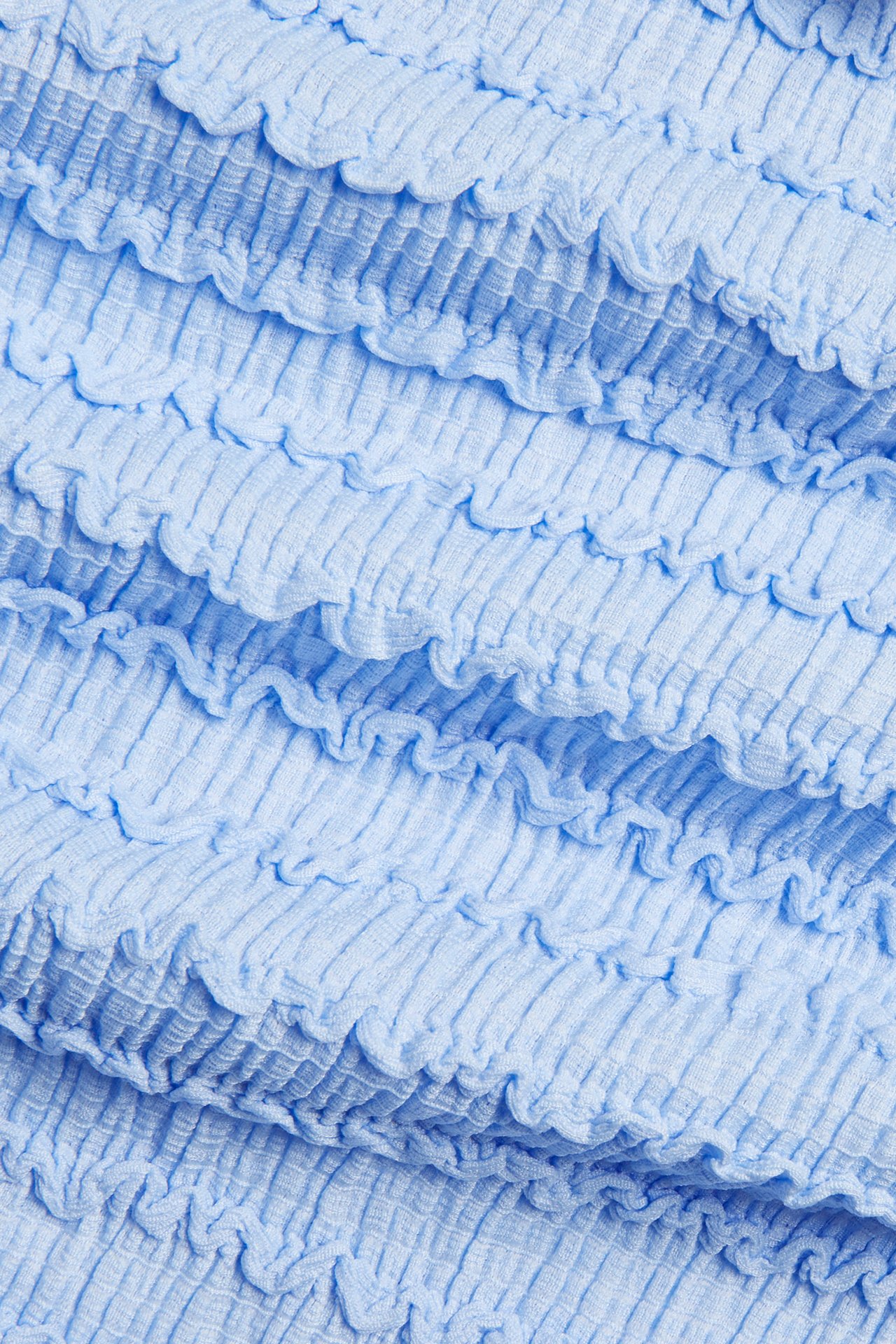 Lähikuva vaaleansinisestä teksturoidusta polyesterisekoitekankaasta.