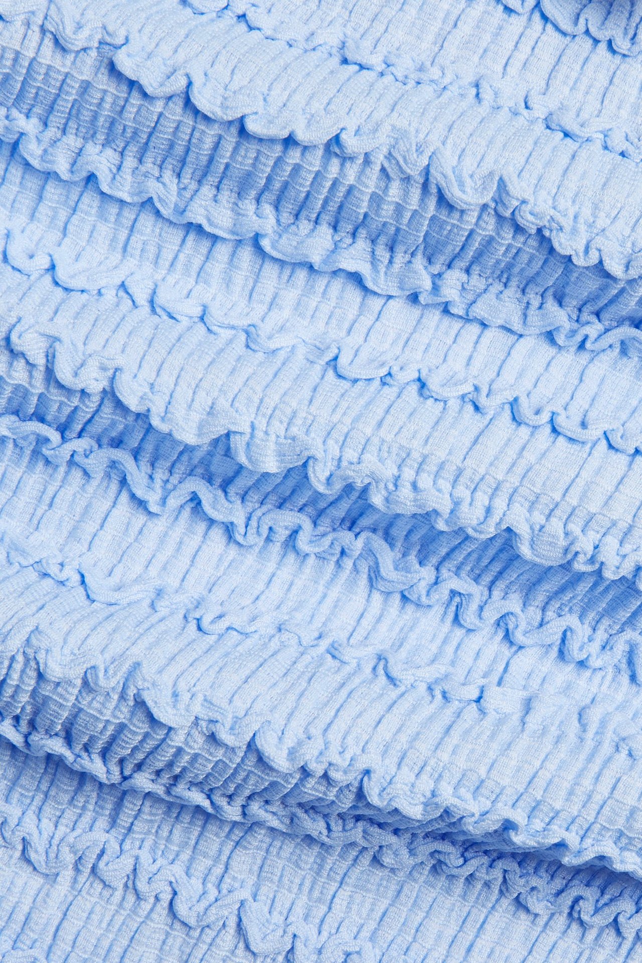 Lähikuva vaaleansinisestä teksturoidusta polyesterisekoitekankaasta.