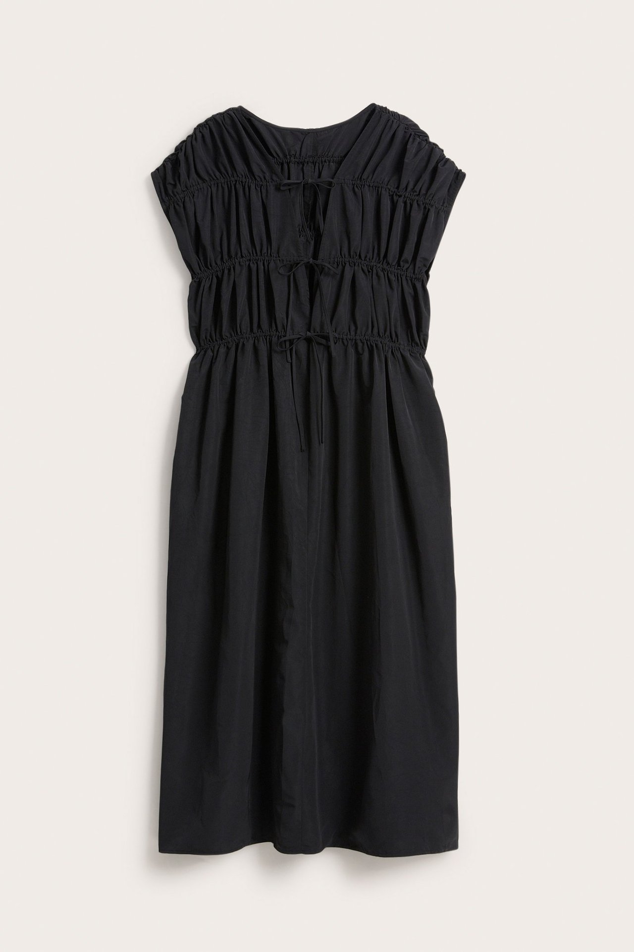 Frontvisning av en svart polyester midi-kjole med rynket overdel og justerbare knutedetaljer.