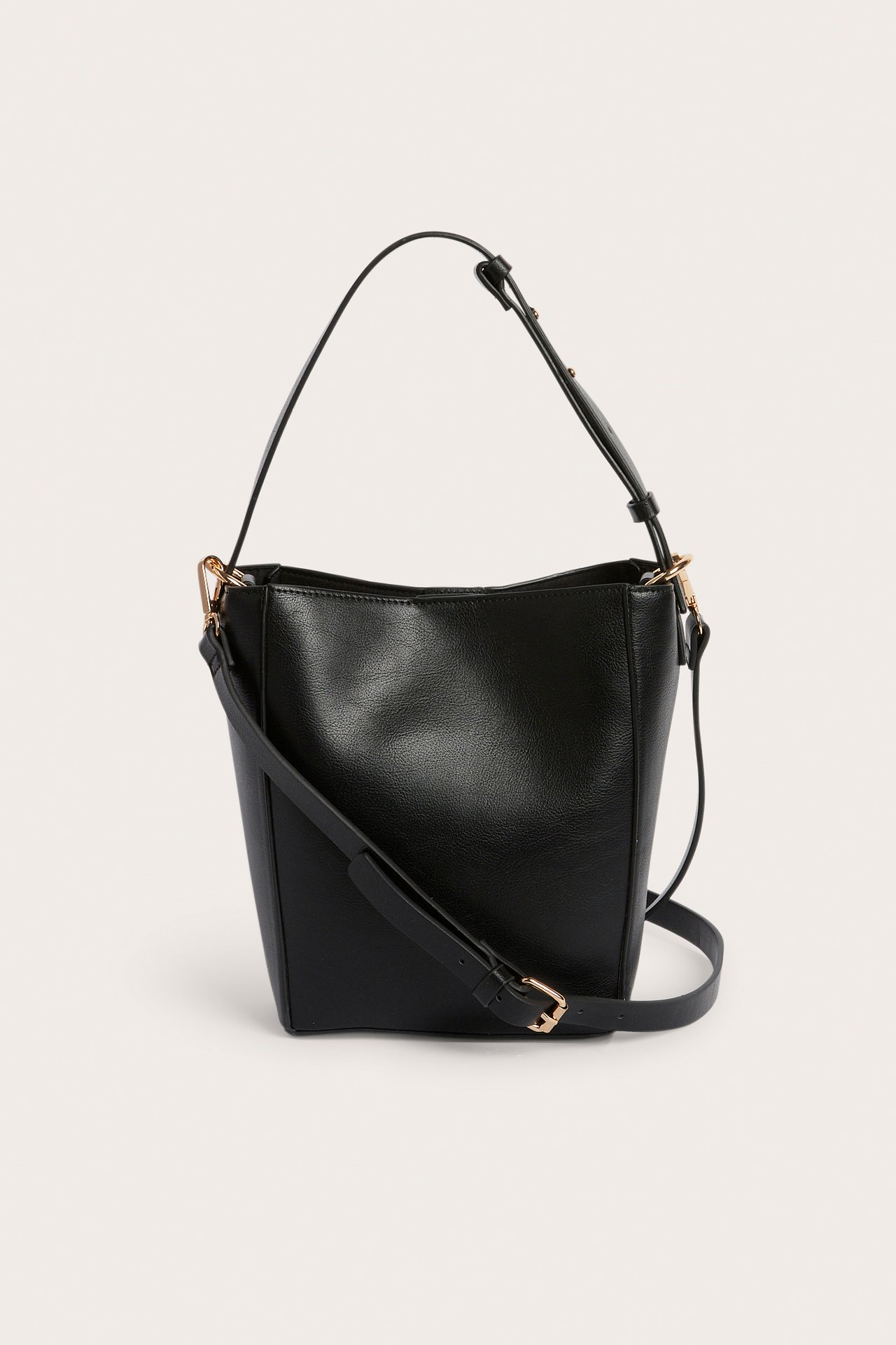 Edestä musta keinonahkainen sankalaukku kahdella säädettävällä hihnalla ja kultaisilla yksityiskohdilla.