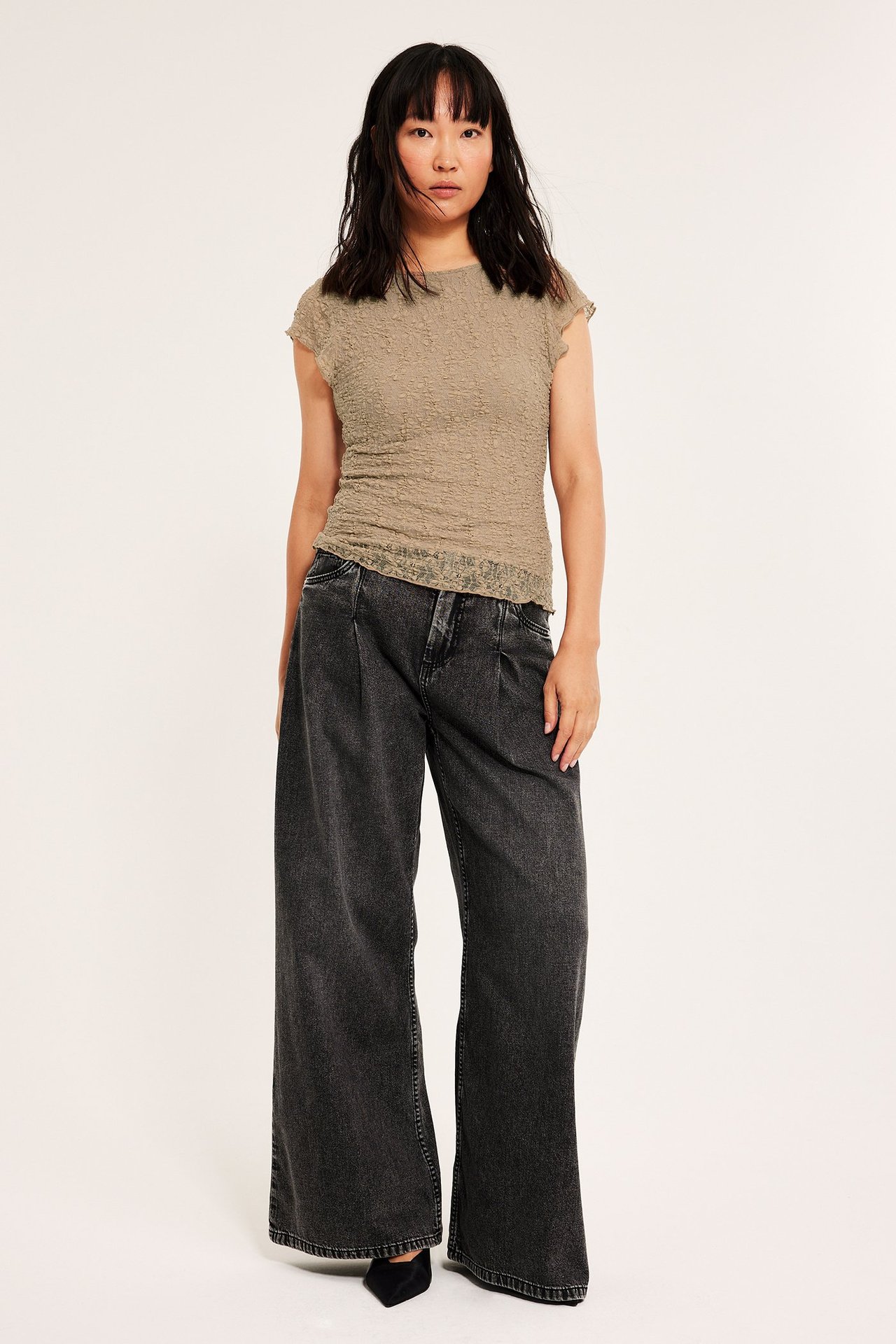 Beige kortärmad topp i spets på kvinna, lång och loose fit, utan ärmar.