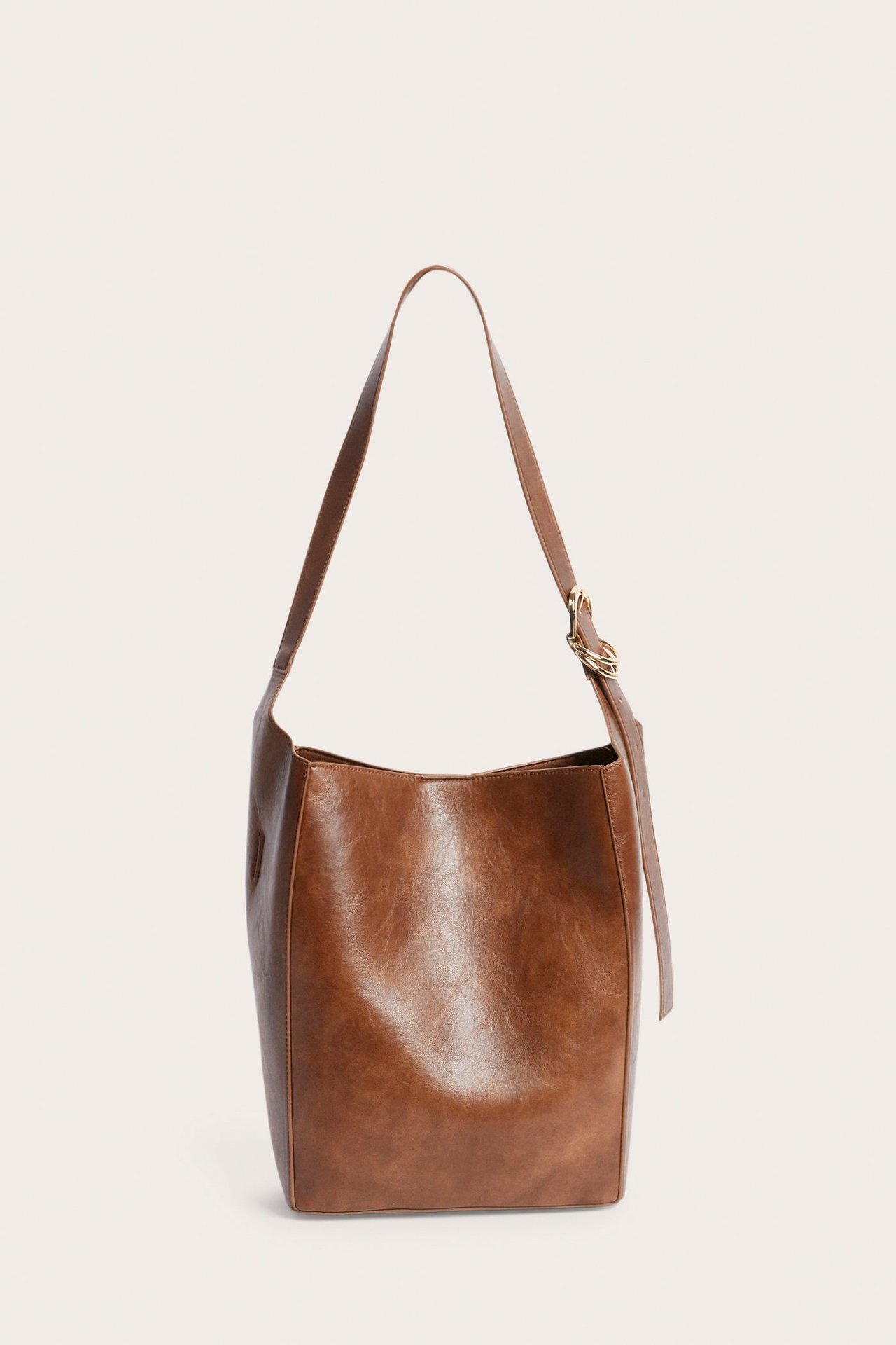 Edestä kuvattu ruskea tekonahkainen olkalaukku säädettävällä hihnalla ja kultaisella renkaalla.