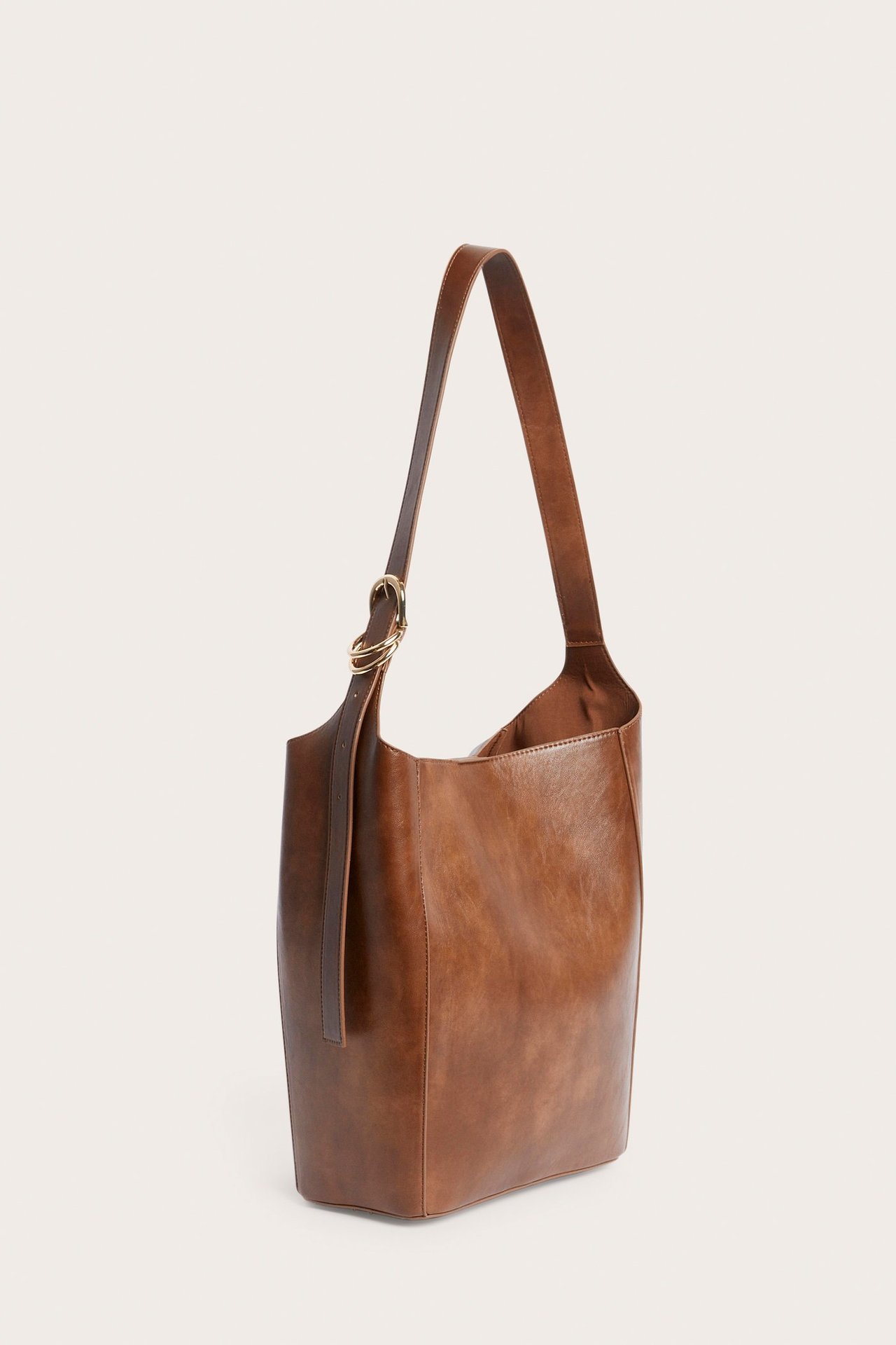Ruskea PU-käsilaukku sivulta, jossa on yksi säädettävä olkahihna ja kultainen rengasdetalji.