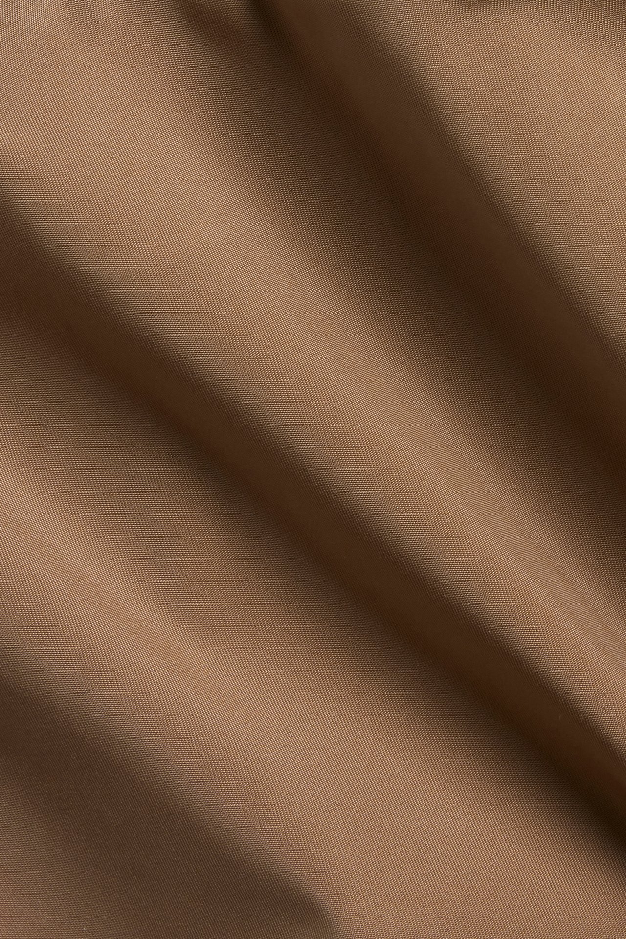 Zbliżenie brązowego, jednolitego mikrowłókna na stringi, z subtelną fakturą.