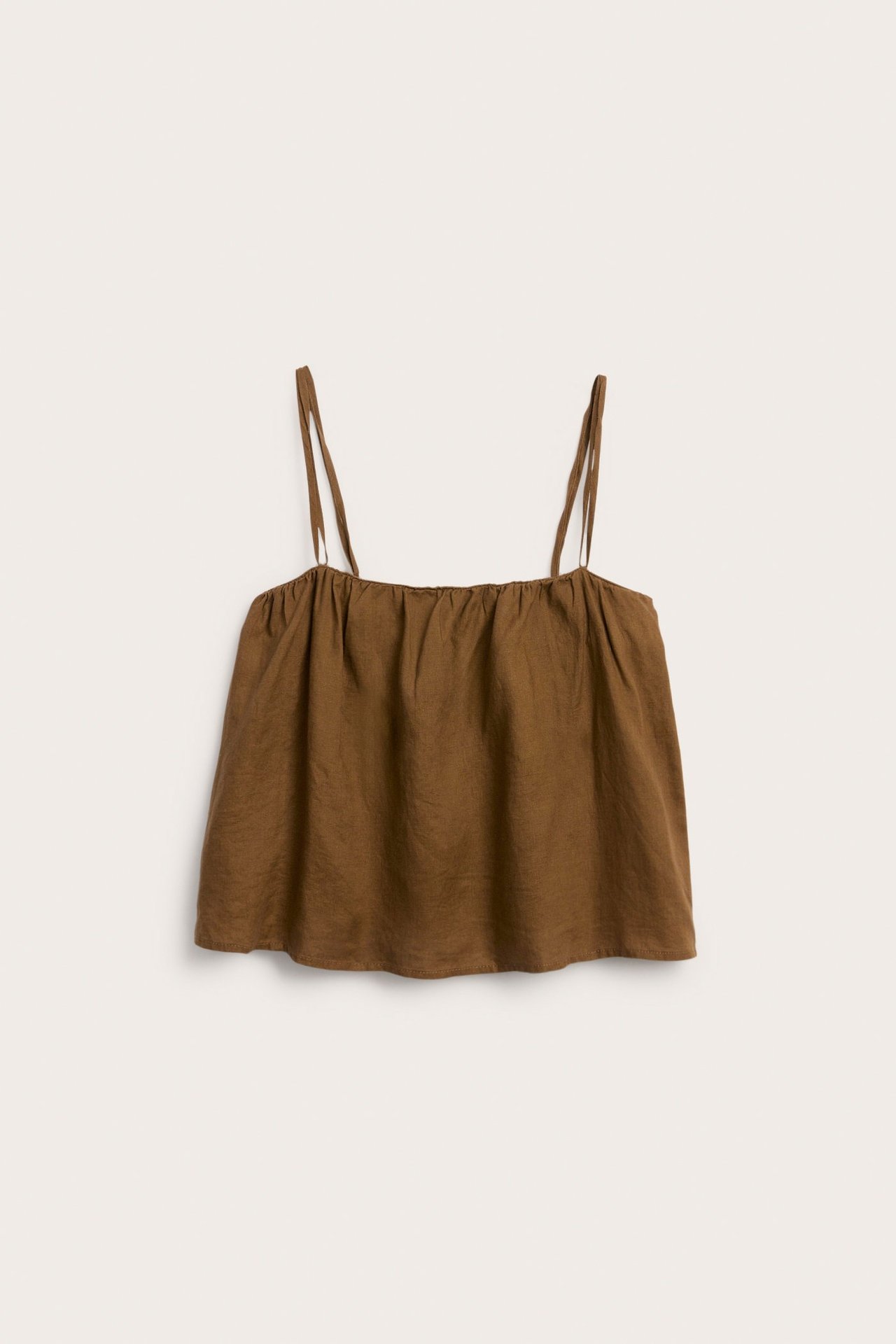 Framifrån, enfärgad brun linnetopp med smala axelband och rynkad halslinning.