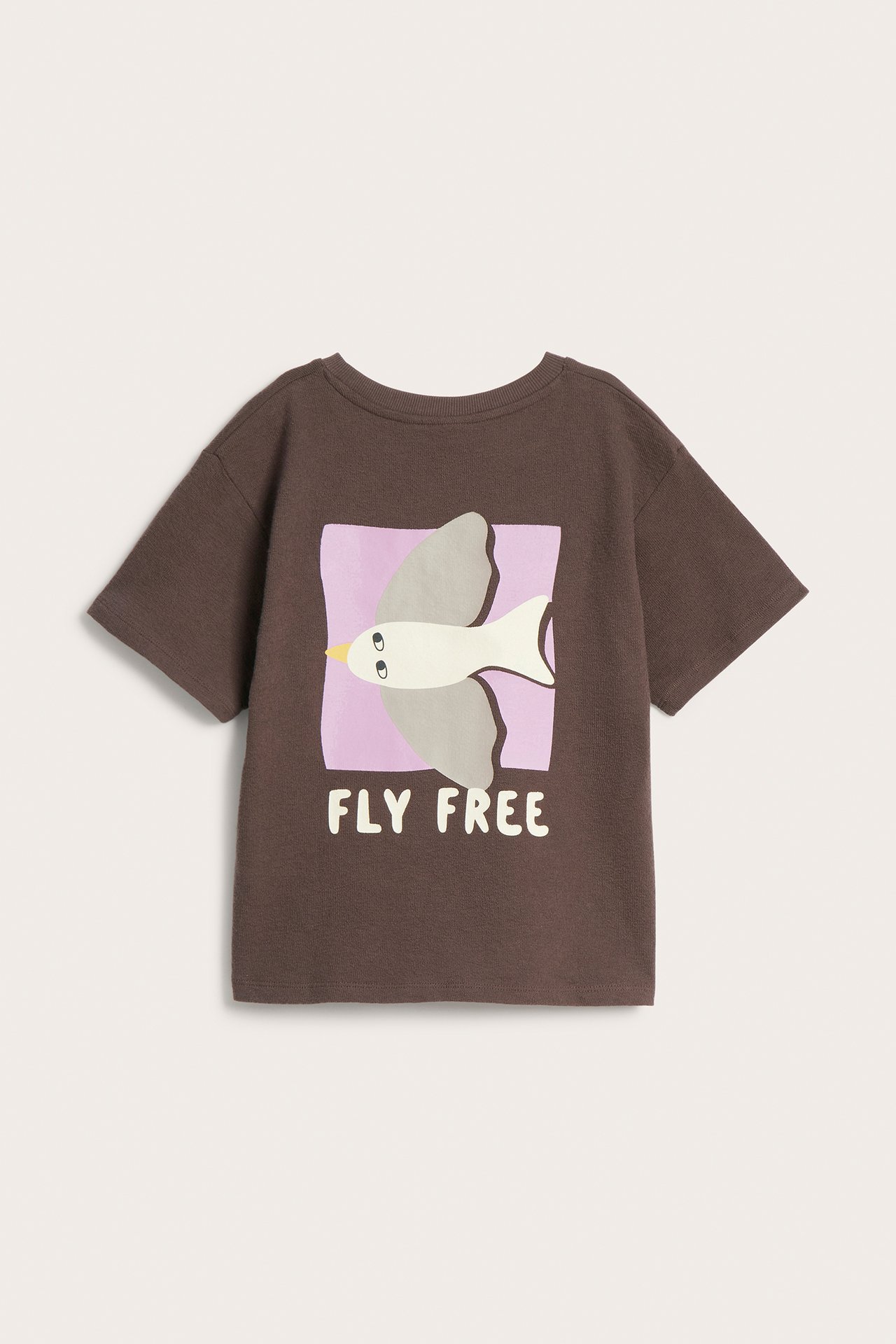 Przód brązowego bawełnianego t-shirtu dla dziecka z szarym nadrukiem ptaka i napisem "FLY FREE".