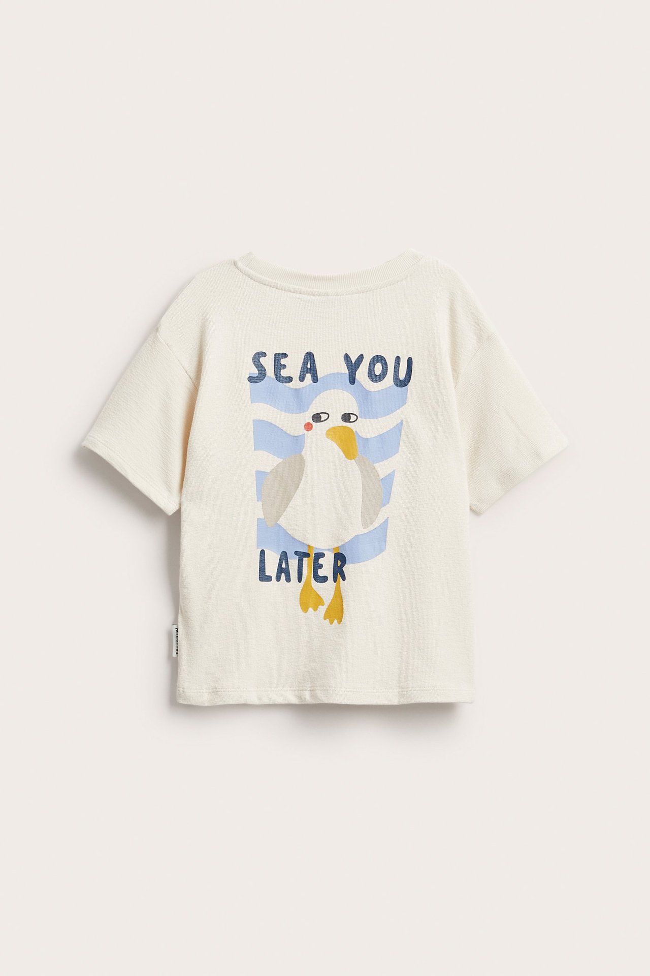 Bakfra: lys beige bomulls-T-skjorte for barn med sjøfugltrykk og teksten "SEA YOU LATER".