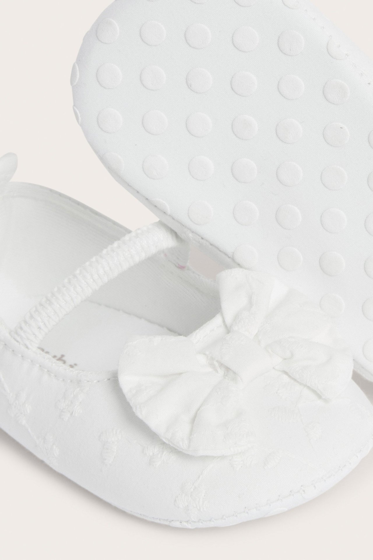 Off-white broderte baby-ballerinasko i bomull med elastisk stropp, sløyfe og antiskli-såle.