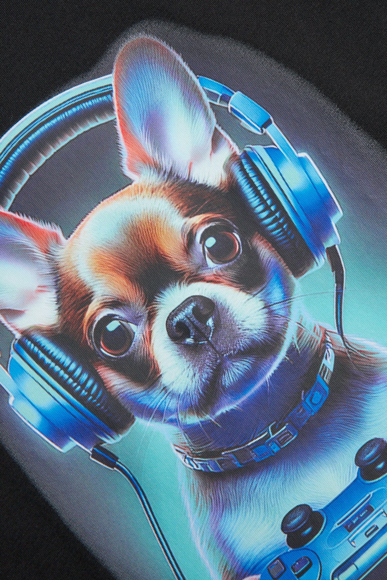 Zbliżenie nadruku na czarnym T-shircie, przedstawiającego psa chihuahua w niebieskich słuchawkach i z kontrolerem.