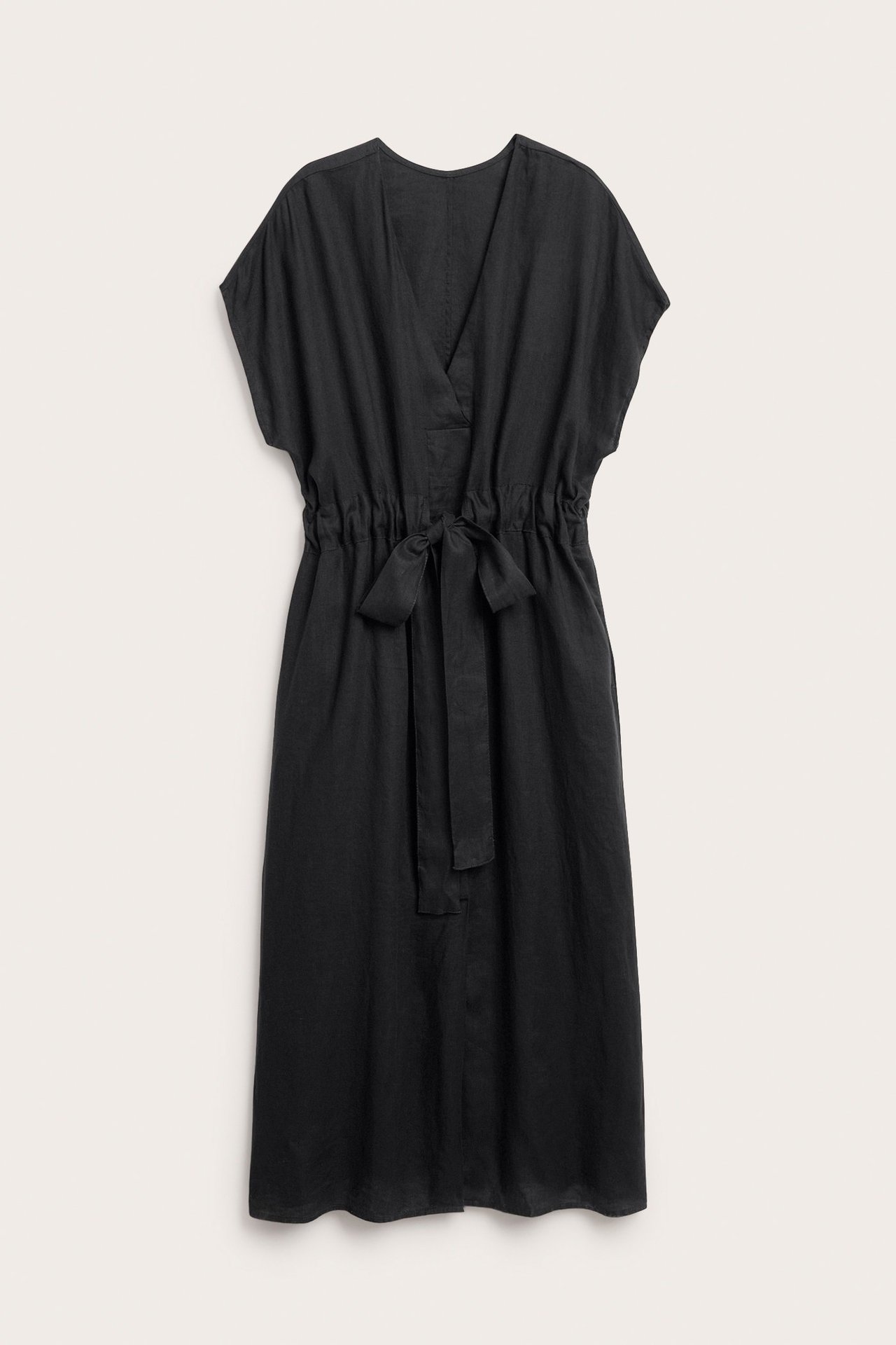 Framsida av svart linneklänning i midilängd med V-ringning, korta ärmar och knytband i midjan.