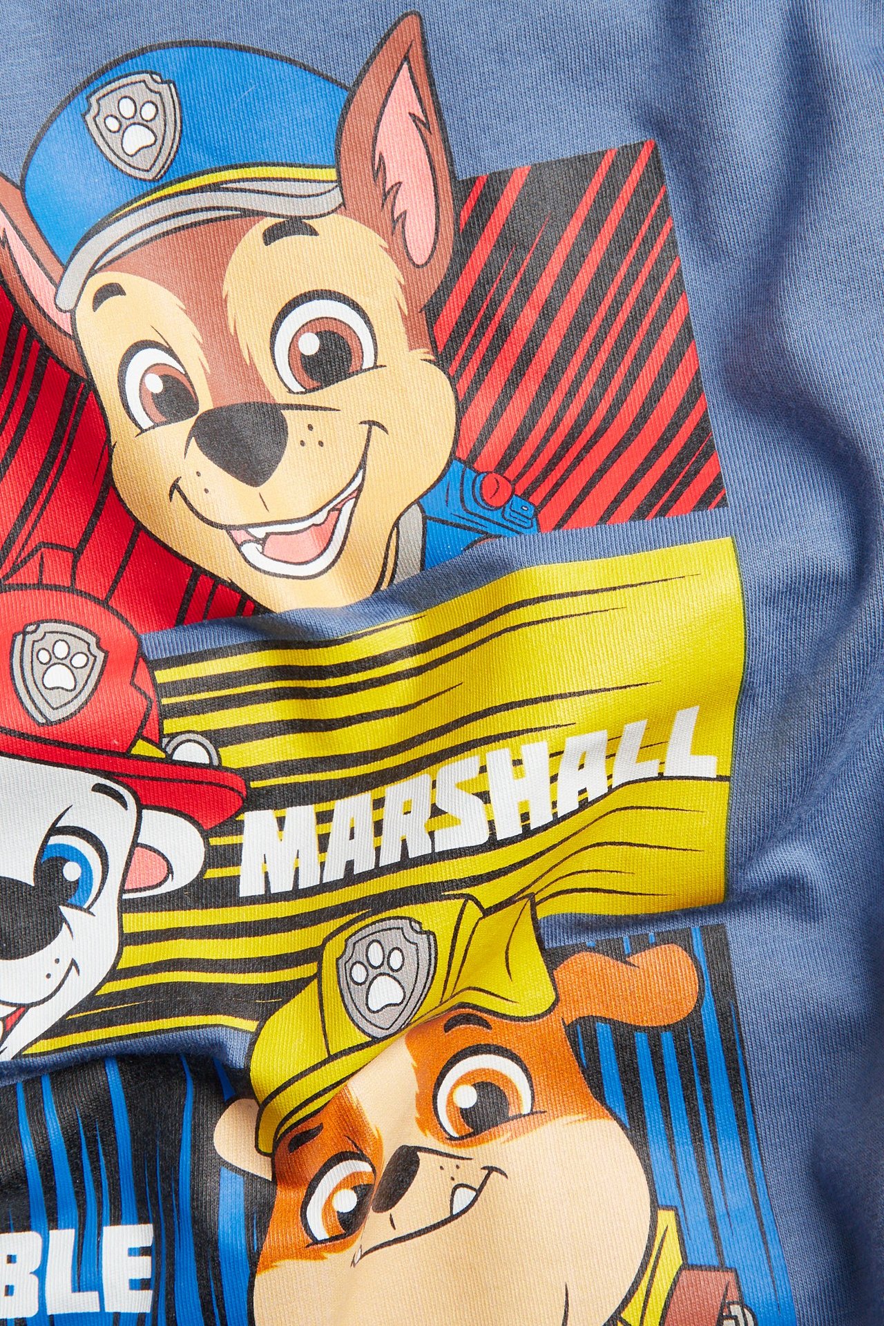 Widok z przodu niebieskiej, bawełnianej koszulki dziecięcej z dużym, kolorowym nadrukiem Psiego Patrolu.