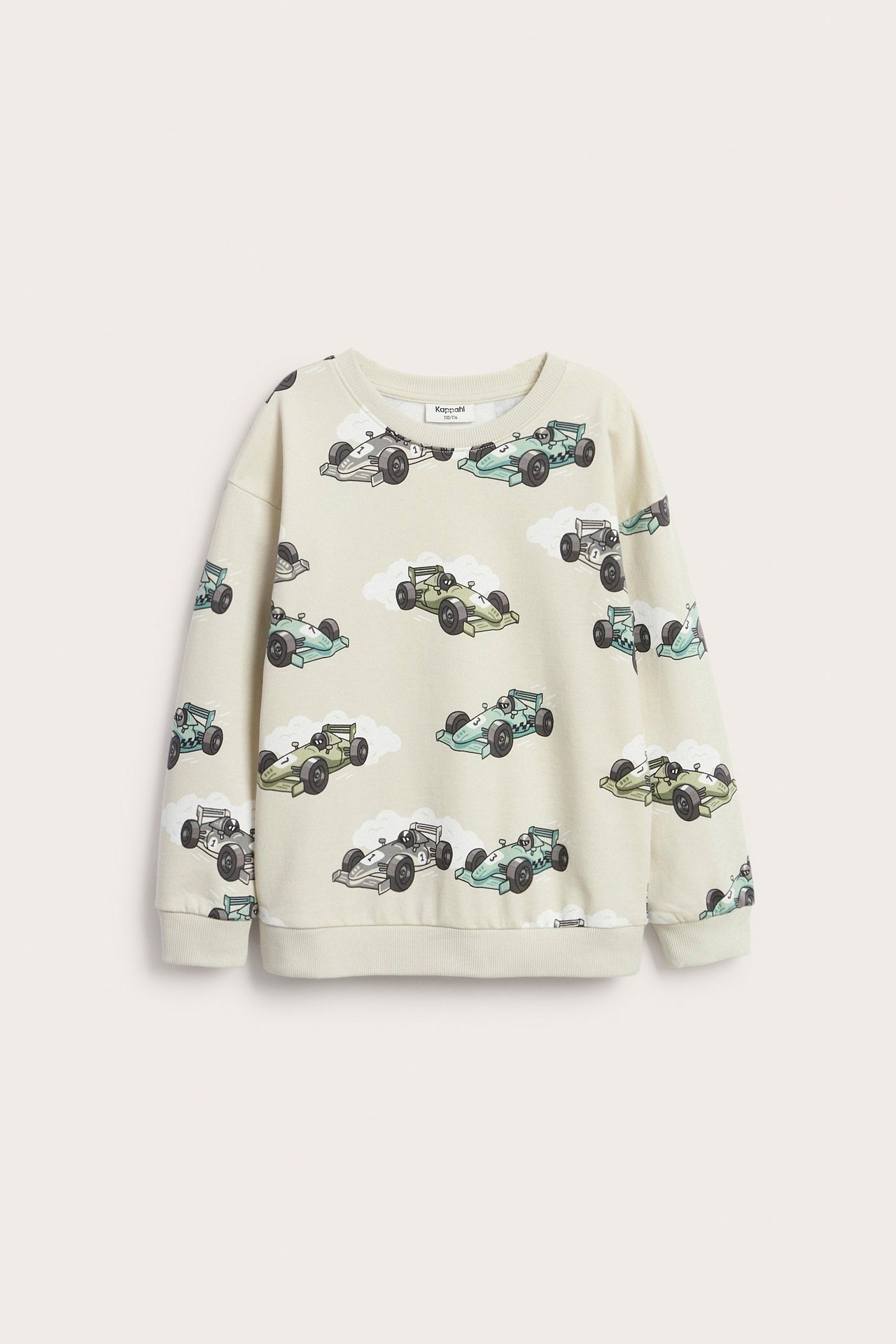 Edestä, lasten beige puuvillapusero, jossa autoaiheinen kokoprintti ja pudotetut olkapäät.