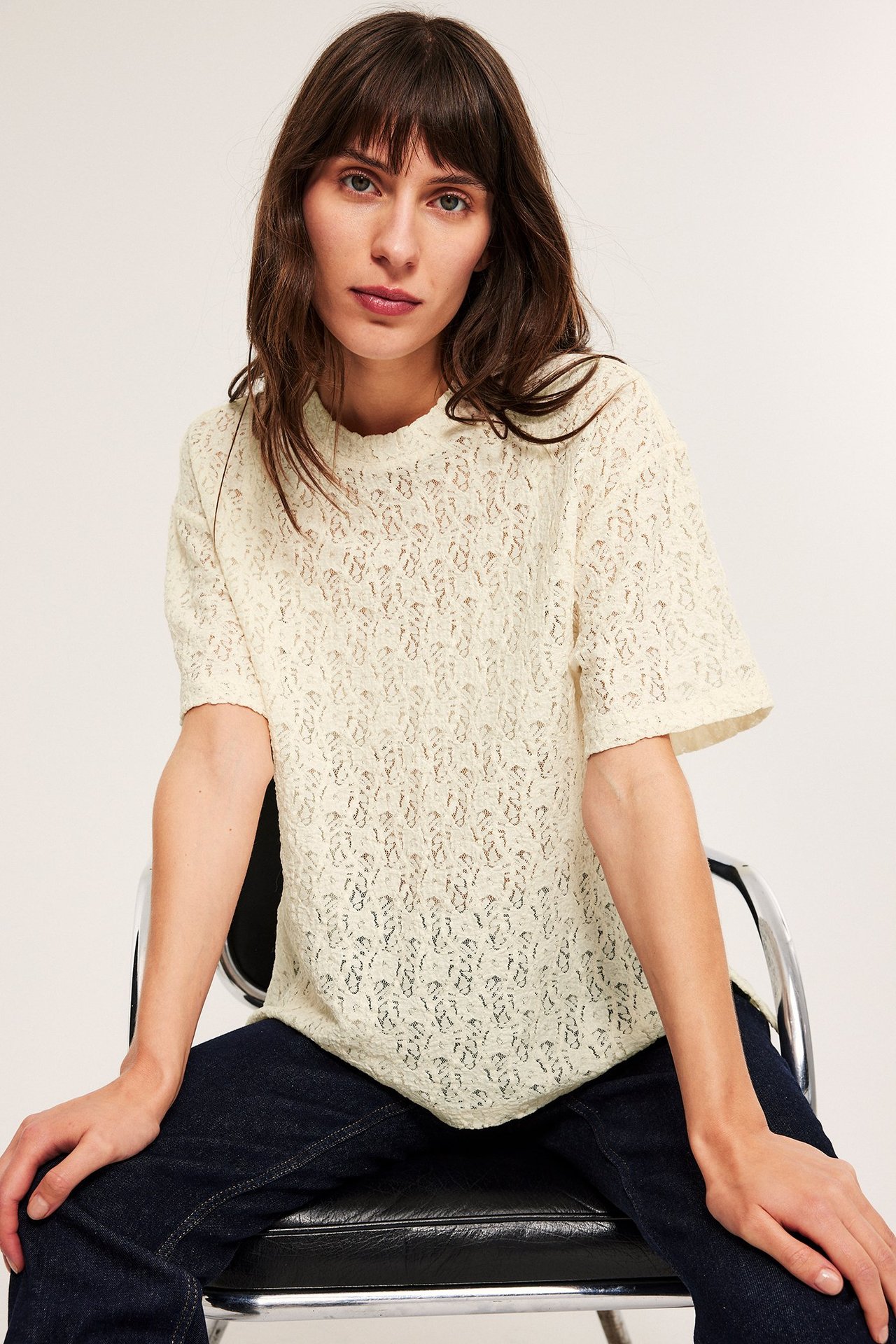 Kvinne har offwhite bluse i åpen arbeidsøking, kort erme, front.