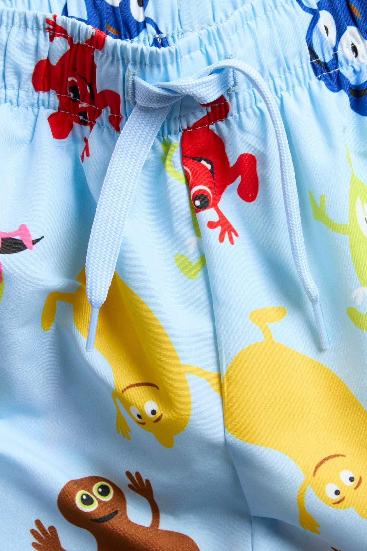 Nærbilde forfra av lyseblå Babblarna-mønstrede badeshorts med lyseblå snøring i midjen.