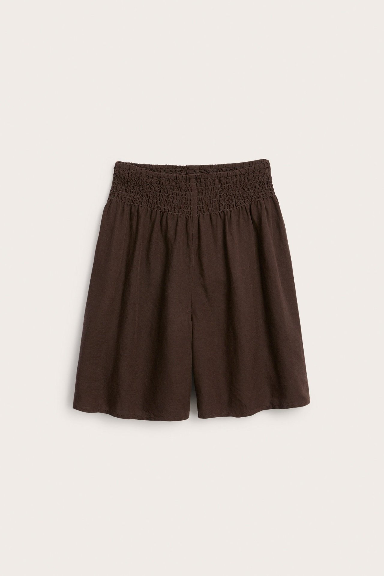 Frontvisning av mørkebrune linblanding-shorts med bred smockmidje og løs passform.