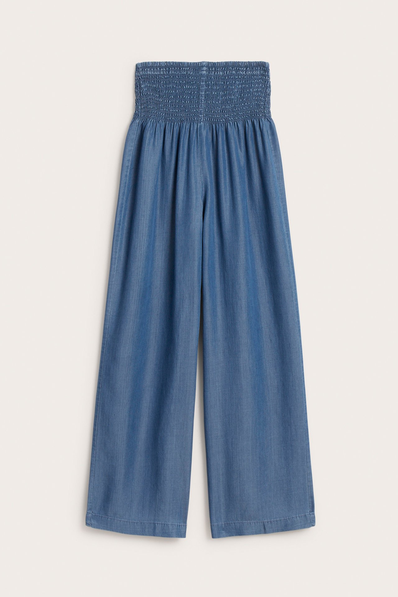 Edestäpäin, vaaleansiniset leveälahkeiset lyocell-housut rypytetyllä korkealla vyötäröllä.