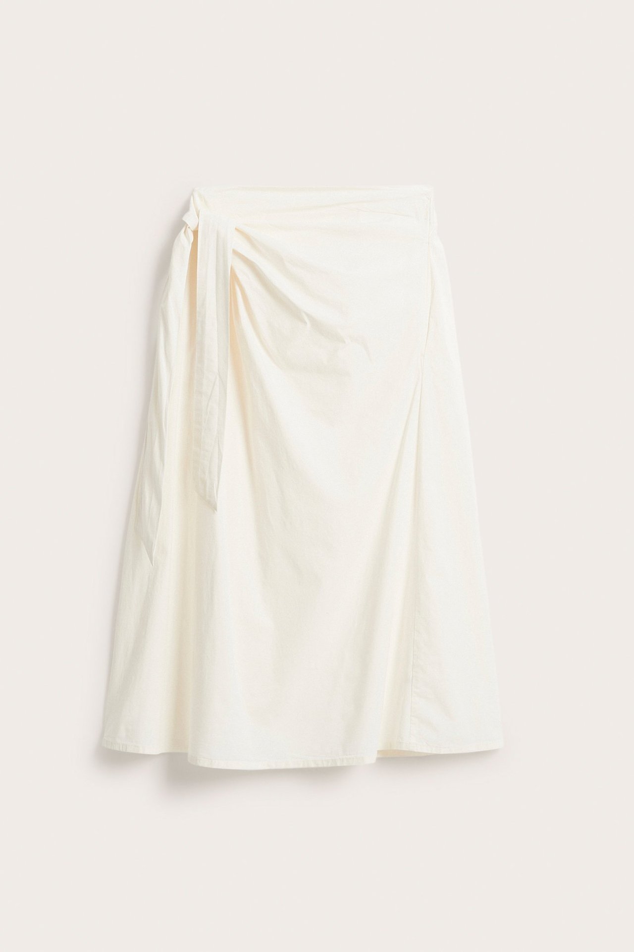 Edestäpäin valkoinen popliini-kietaimihame, jossa sivusidonta ja A-linjainen malli.