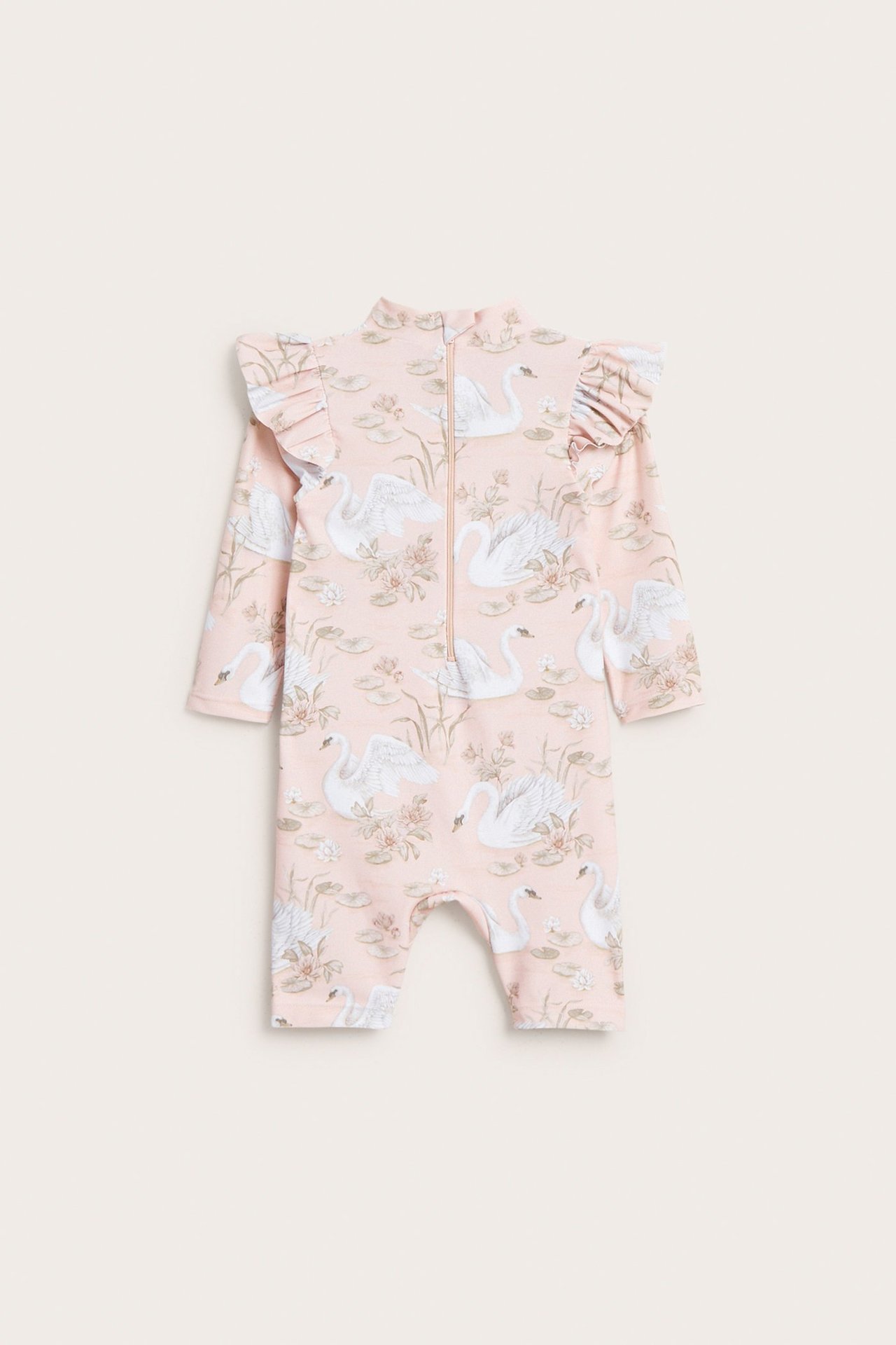 Forfra, en lys rosa baby-UV-romper med hvitt svane- og vannliljemønster og skulderfriller.