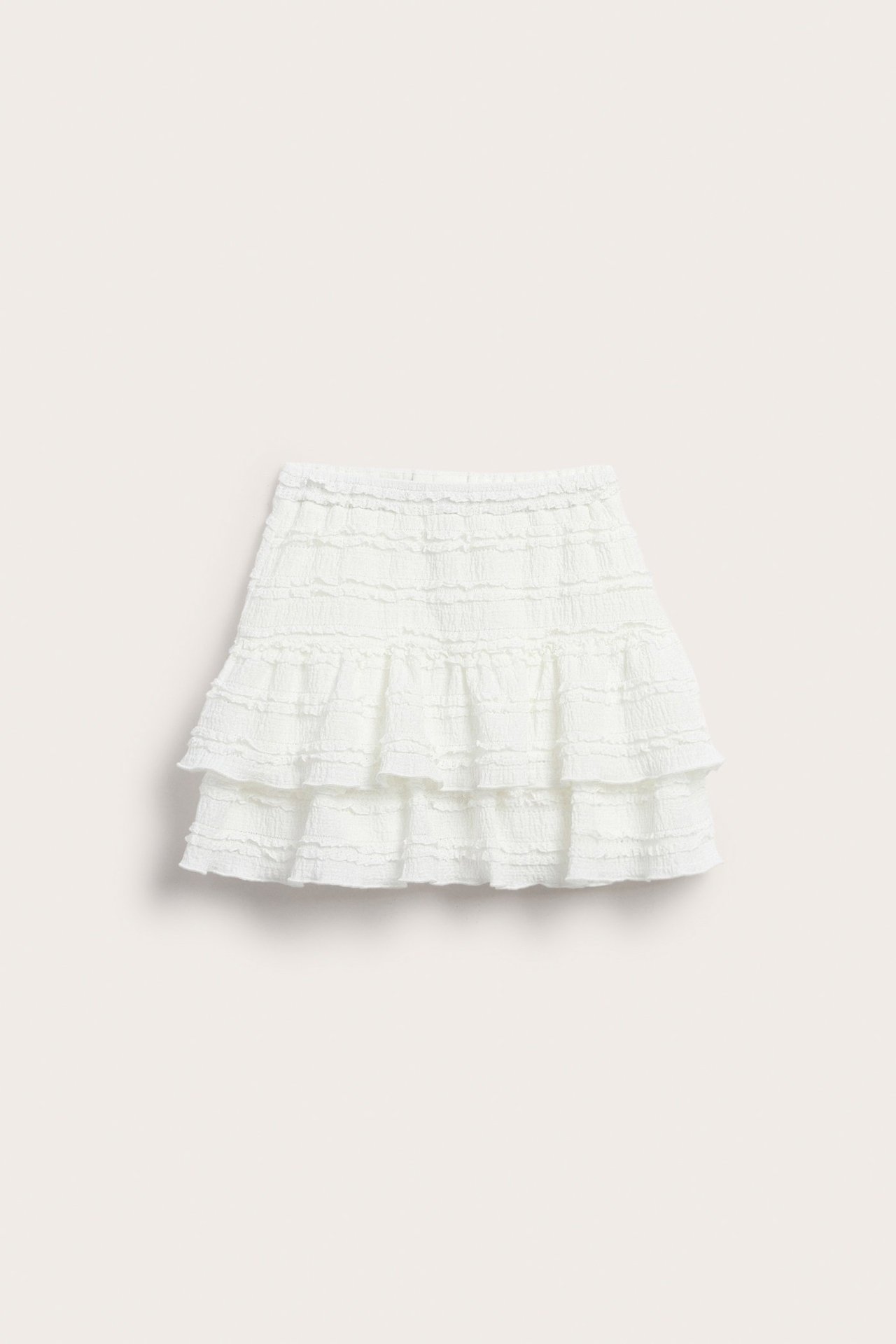 Framifrån, kort offwhite volangkjol i spets med resår och justerbar midja.