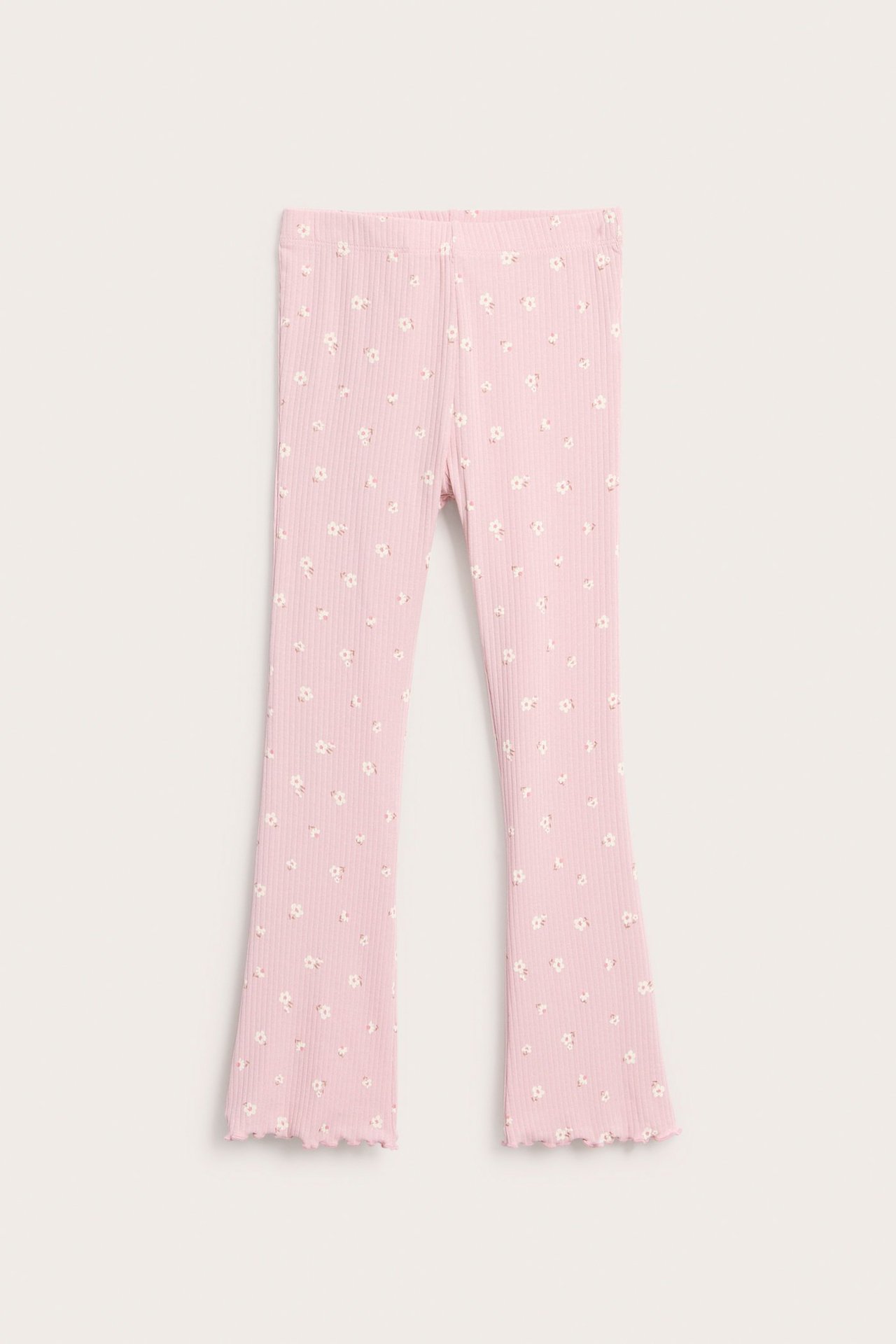 Widok z przodu: Jasnoróżowe prążkowane legginsy rozszerzane z białym kwiatowym wzorem i falowanymi nogawkami.