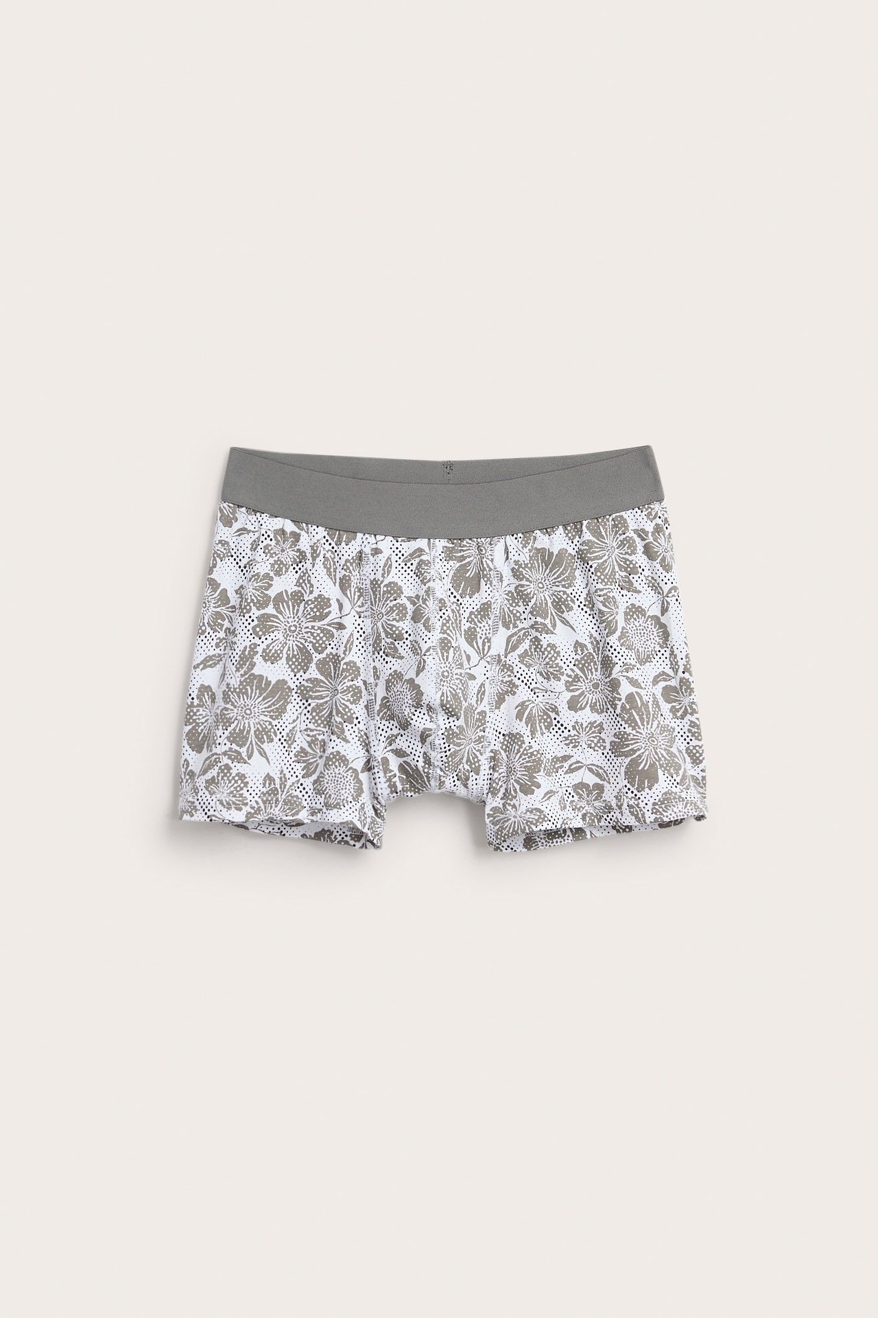 Frontbilde av hvite jersey boxershorts for menn med grått blomstermønster og grå elastisk linning.
