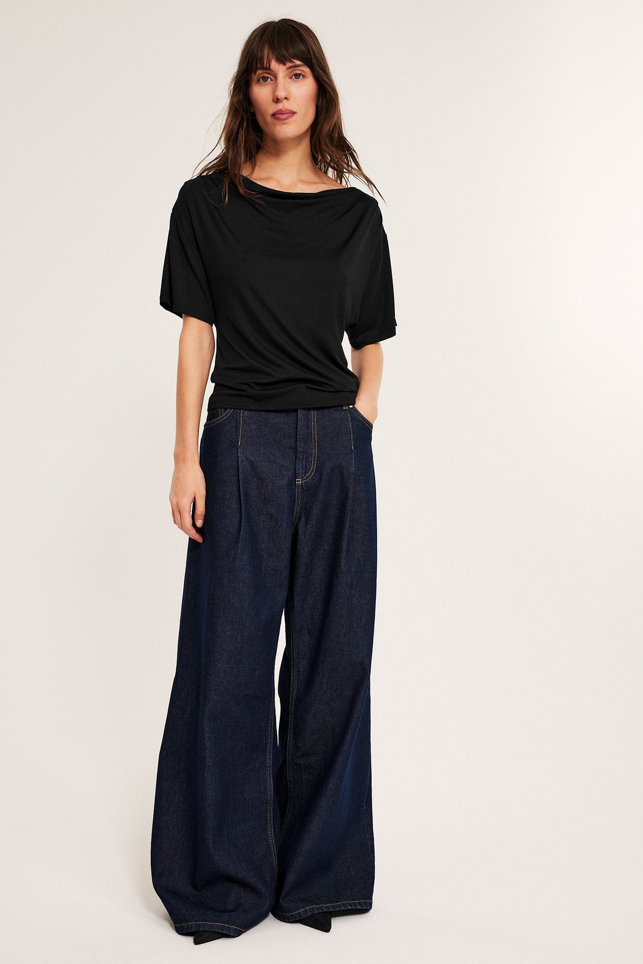 Musta lyhythiha viscose-toppi, naisella, päällä farkut.