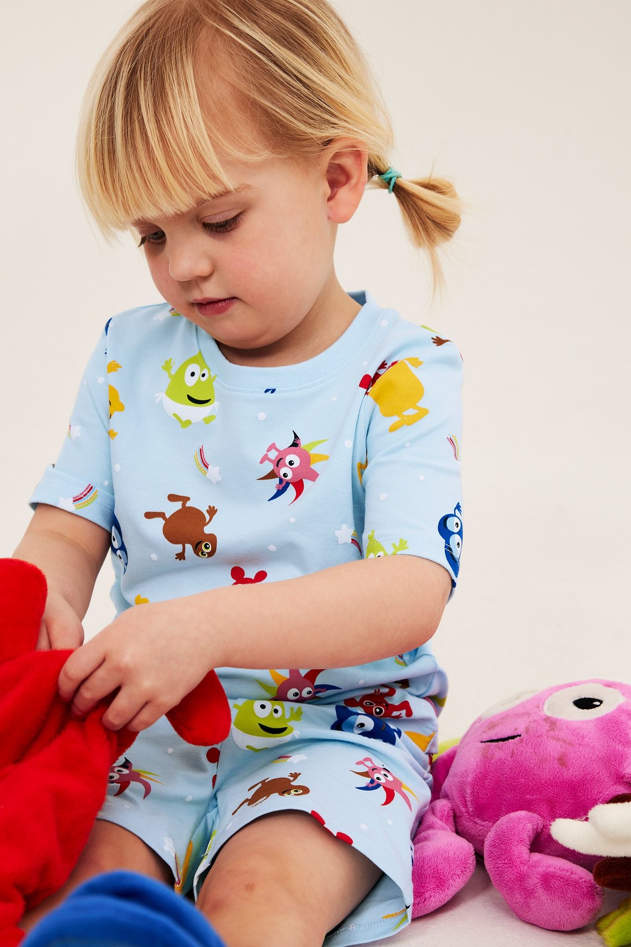 Lähikuva edestä lapsesta yllään vaaleansininen Babblarna-kuvioinen puuvillapyjamassetti.