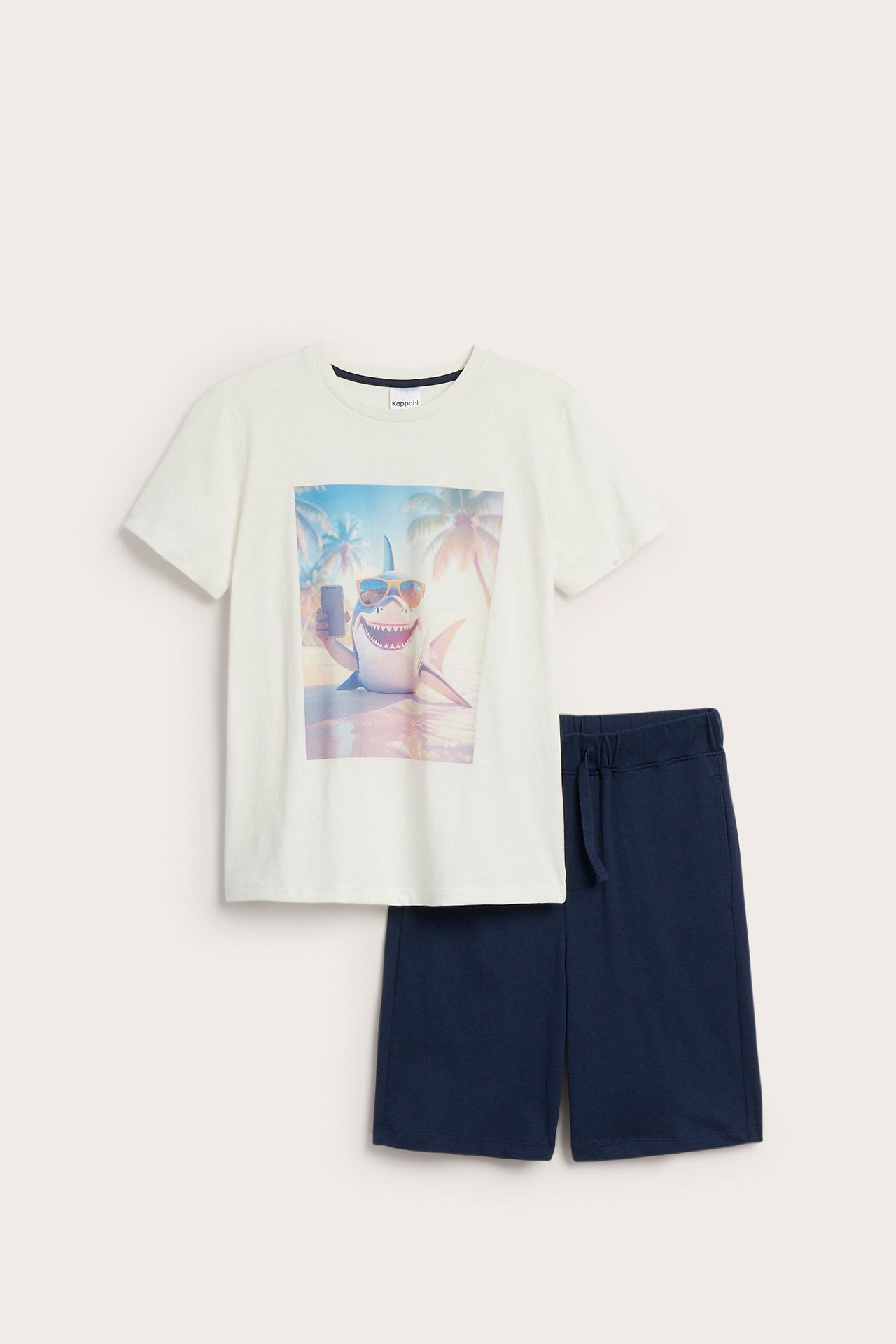 Lasten luonnonvalkoinen puuvillainen lyhythihainen pyjama yläosa hainkuvalla ja laivastonsiniset shortsit, edestä.