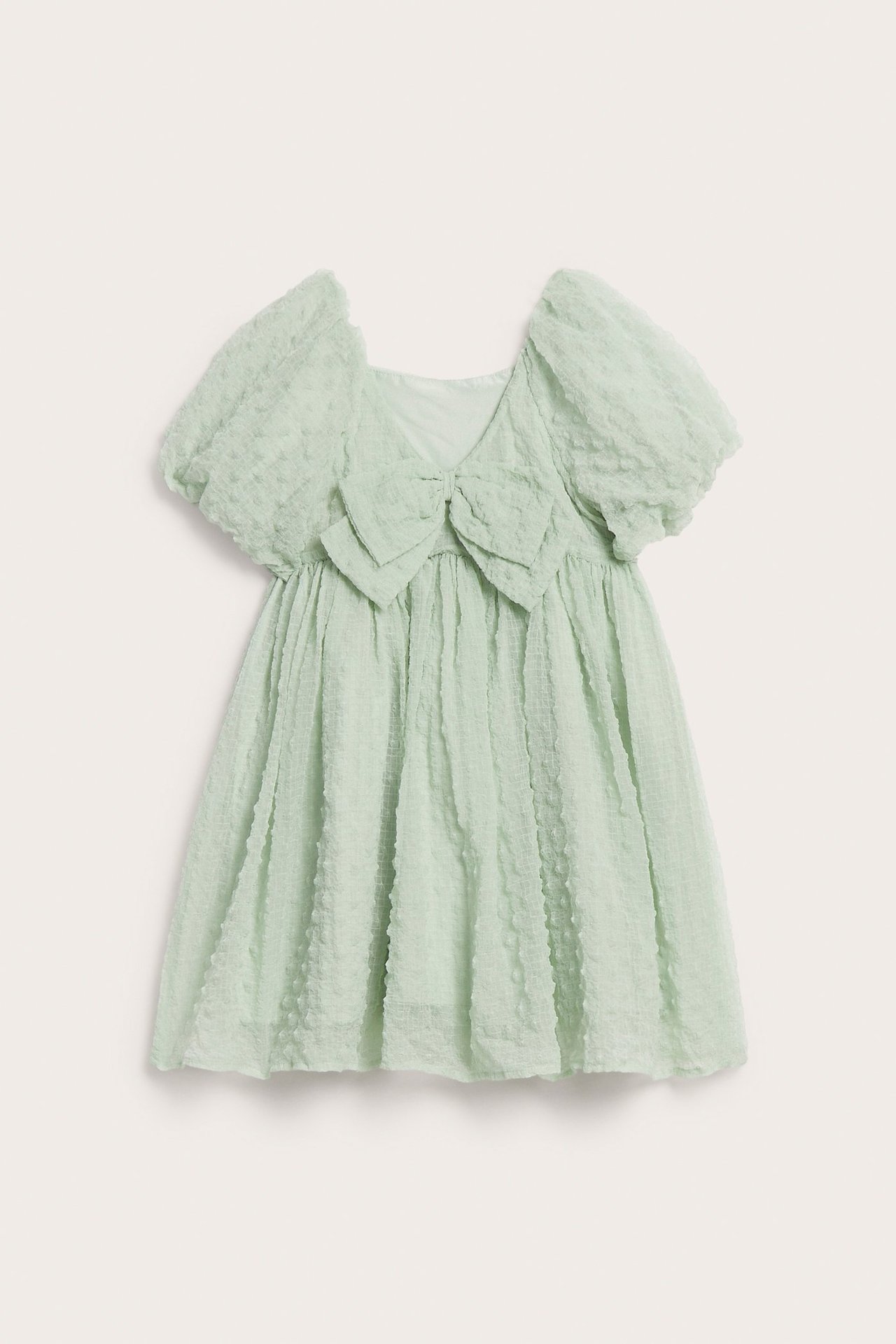 Edestä päin: vaaleanvihreä lasten runsas sifonkimekko puhvihihoilla ja isolla rusetilla.