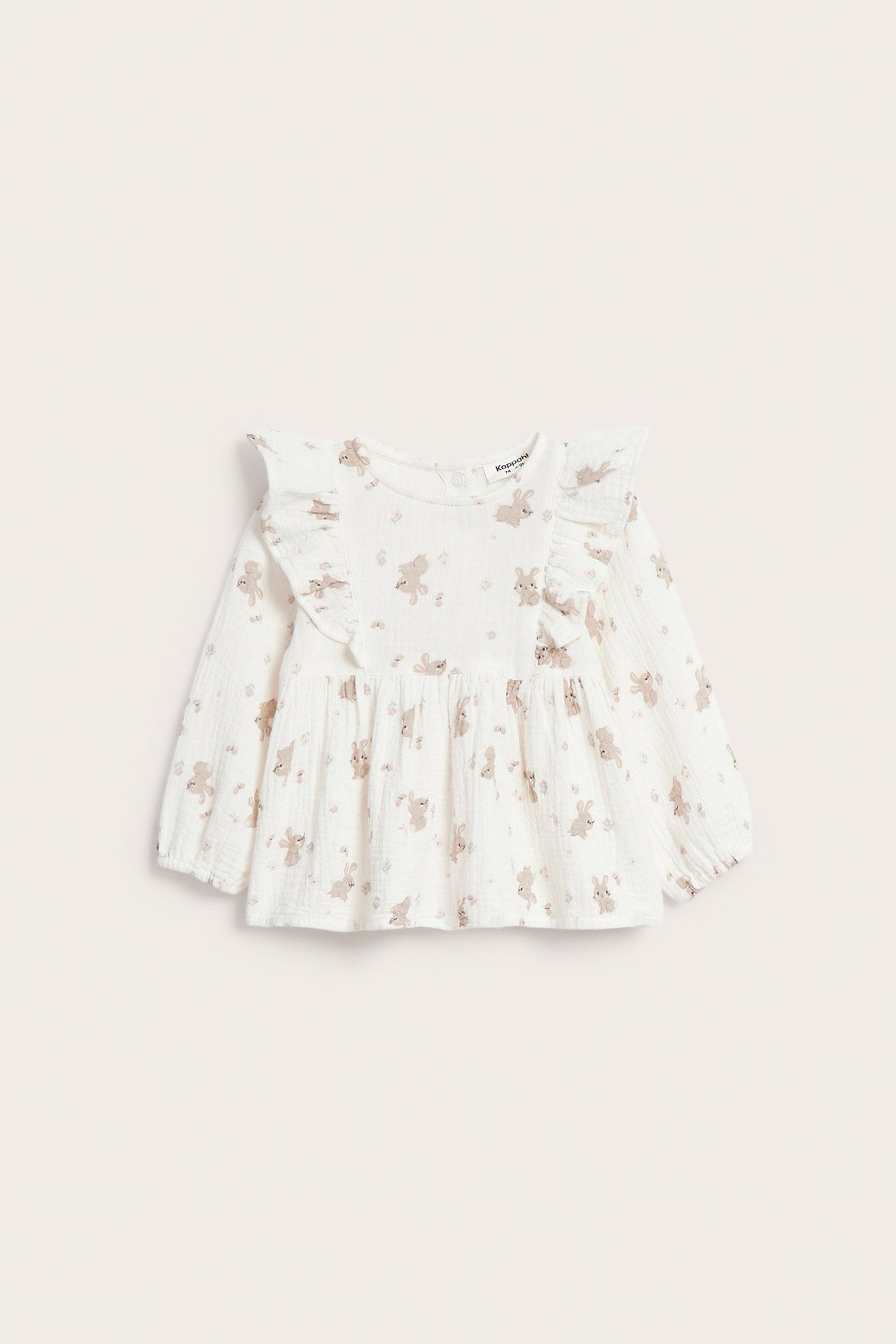 Frontvisning av en offwhite babybluse i musselin med brunt kaninmønster, lange ermer og volangdetaljer.