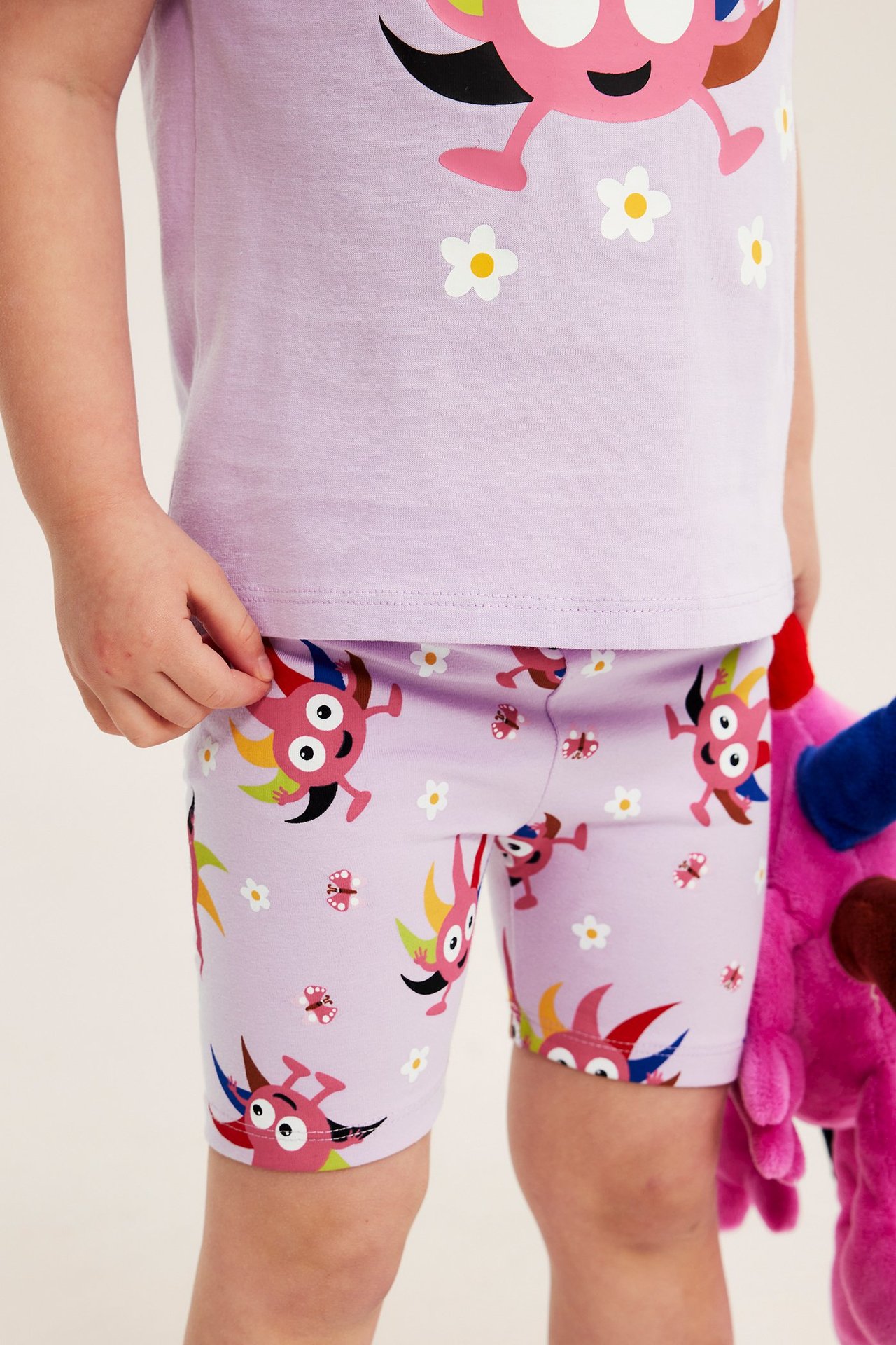 Frontvy: Barns lila Babblarna-mönstrade cykelshorts med resår i midjan, burna med en t-shirt.