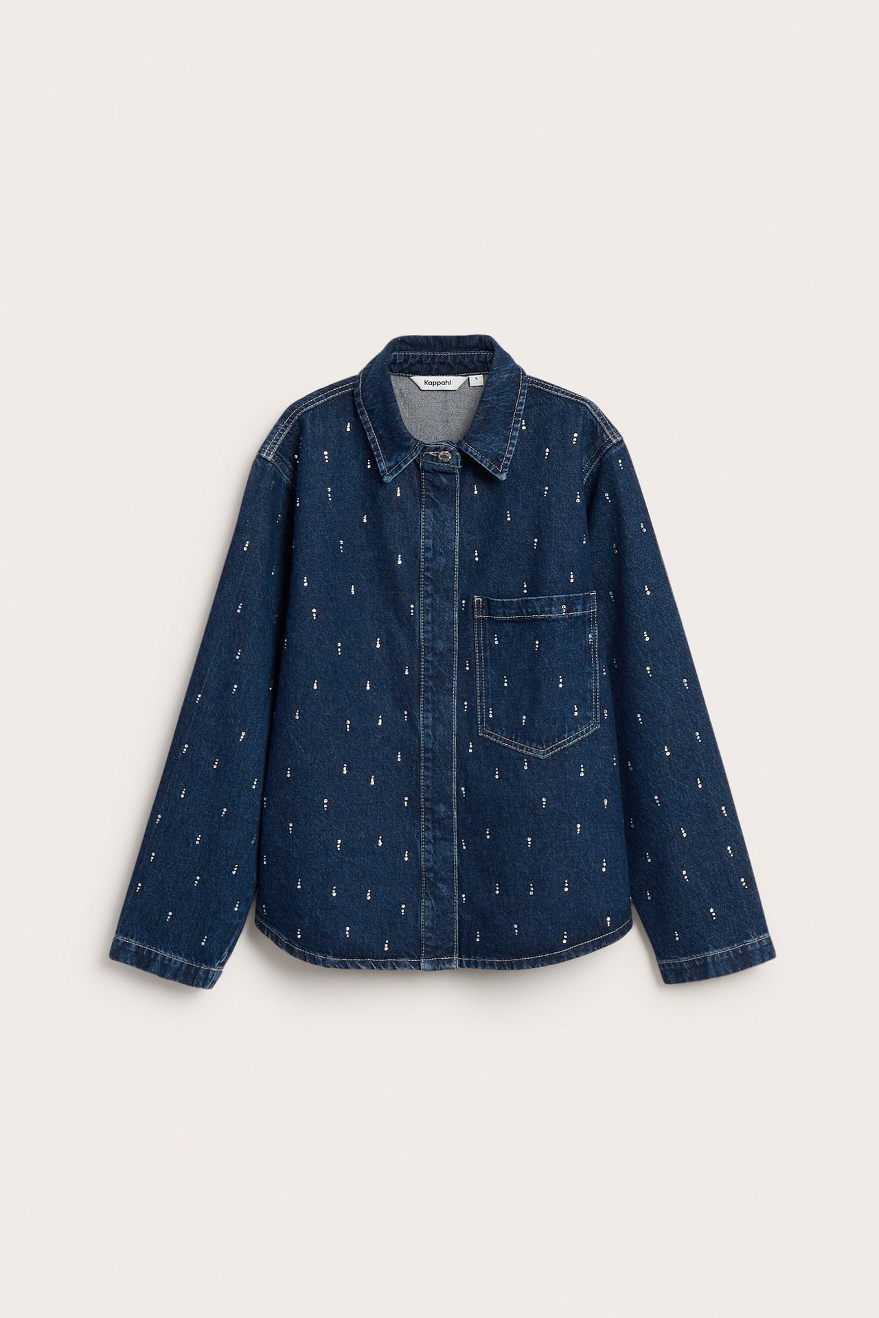 Frontvy av blå jeansskjorta med små vita strassdetaljer och bröstficka.